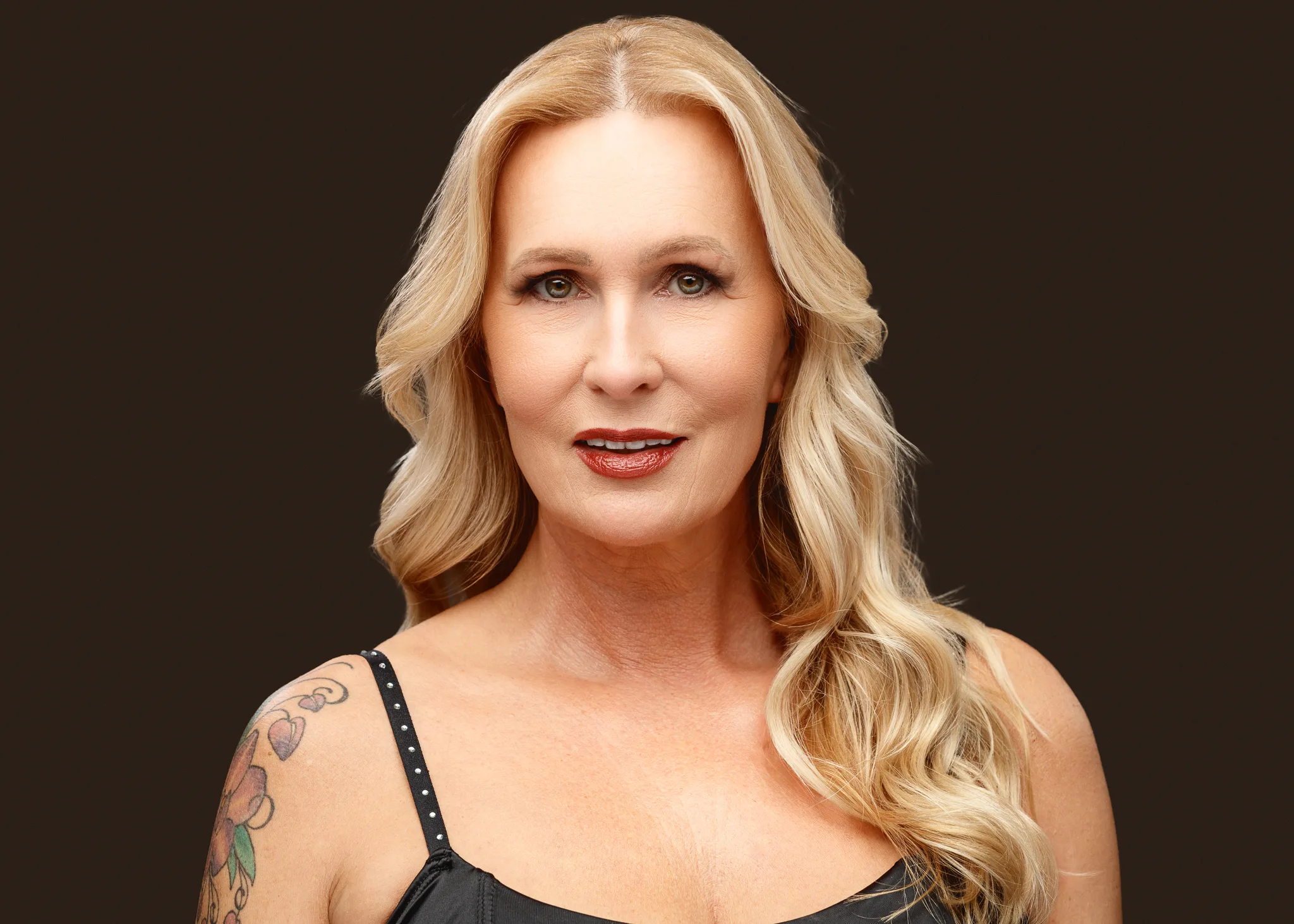 Studio portrait of blonde woman with shoulder tattoo