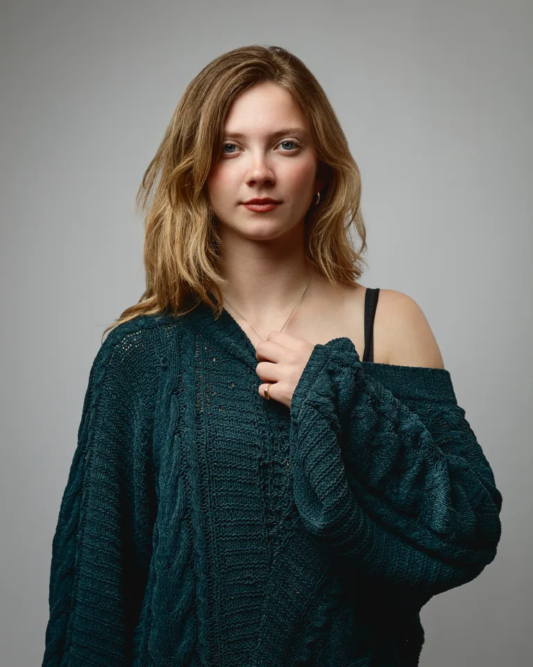 Woman in green jumper against grey background