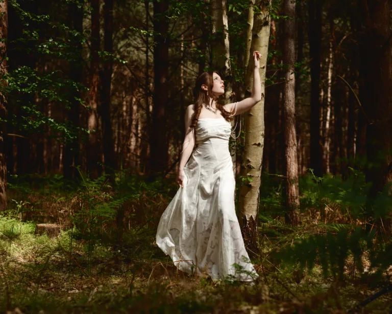 Woman in white dress standing in forest