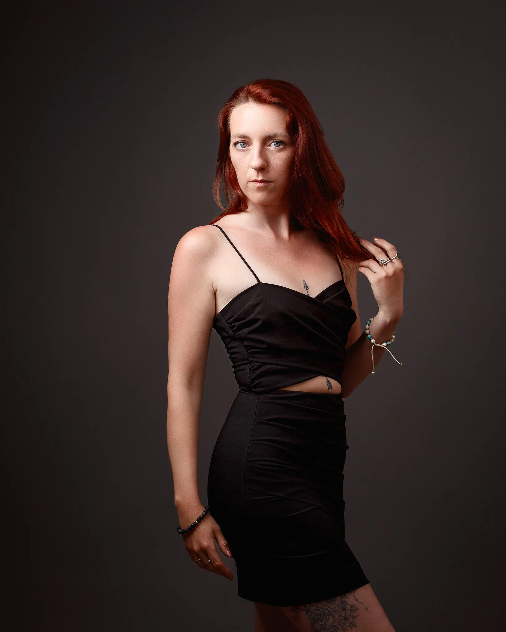 Red-haired woman in black dress studio portrait