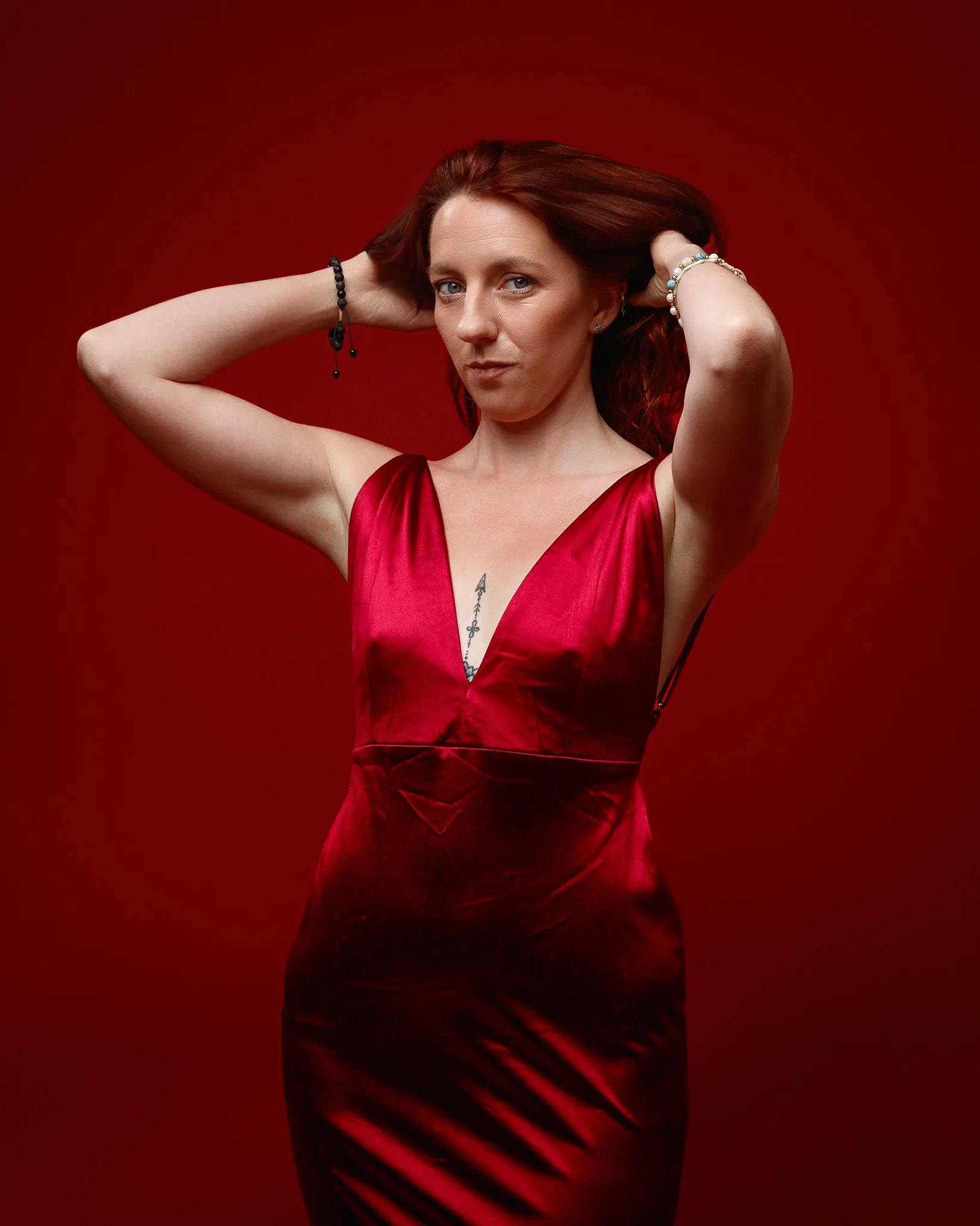 Woman in red satin dress against red backdrop