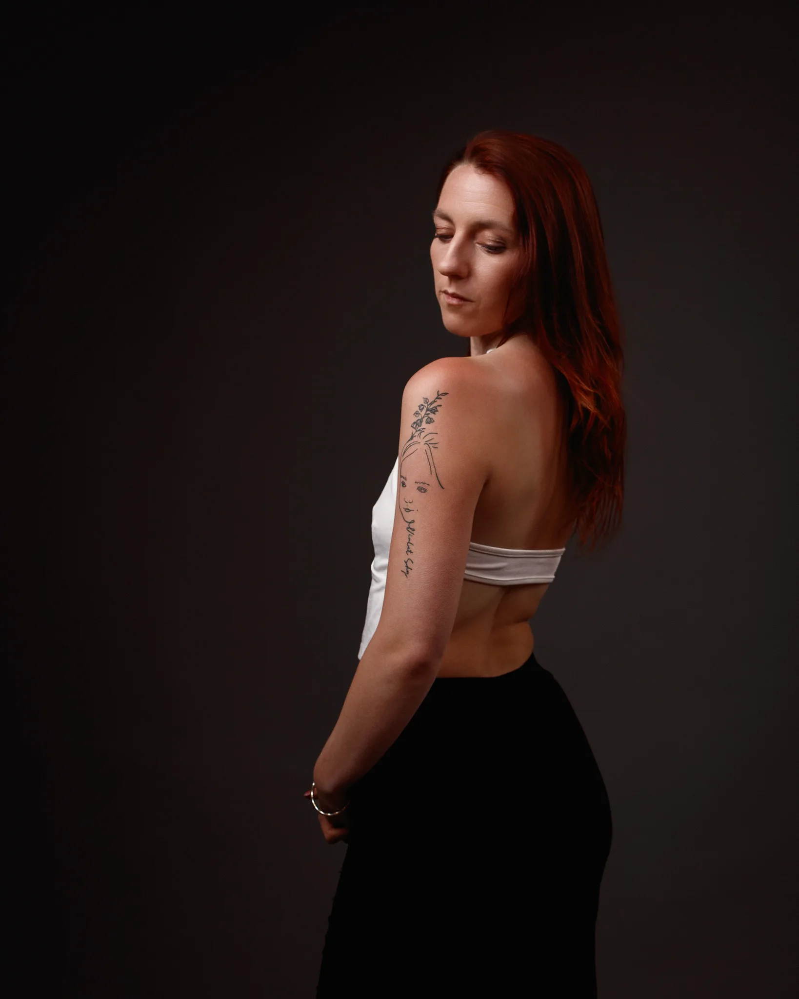 Woman with arm tattoo in studio portrait