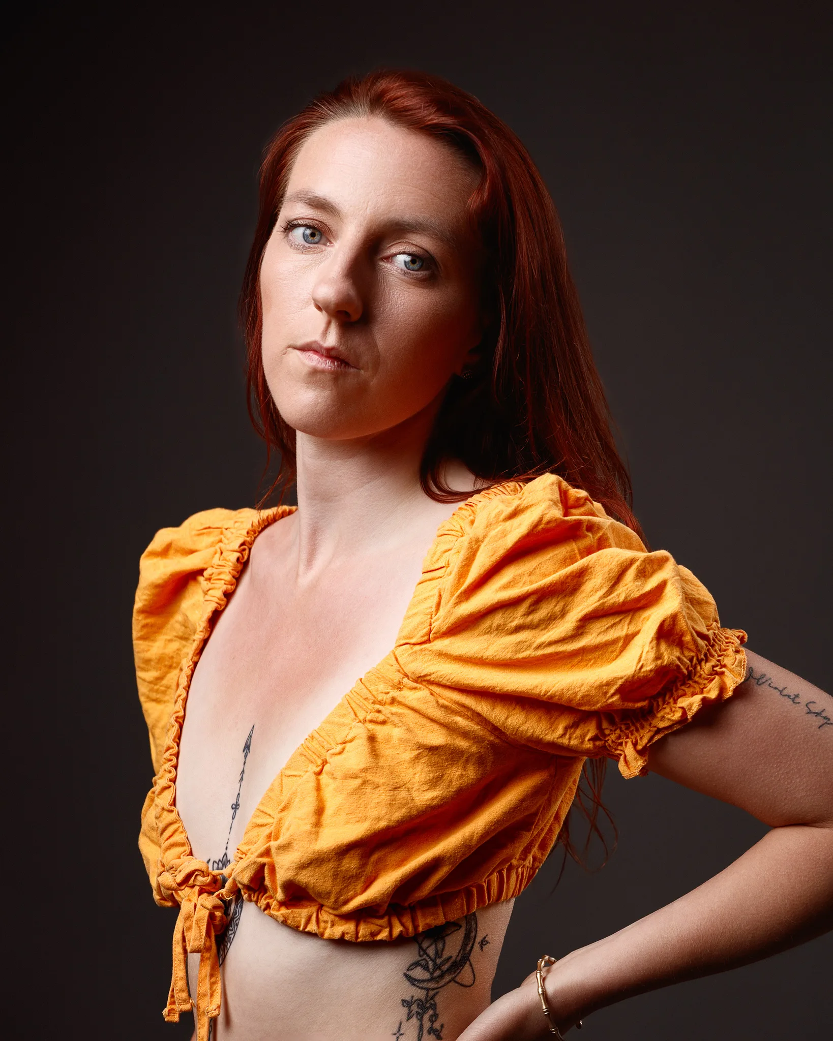 Studio portrait of red-haired woman in yellow blouse