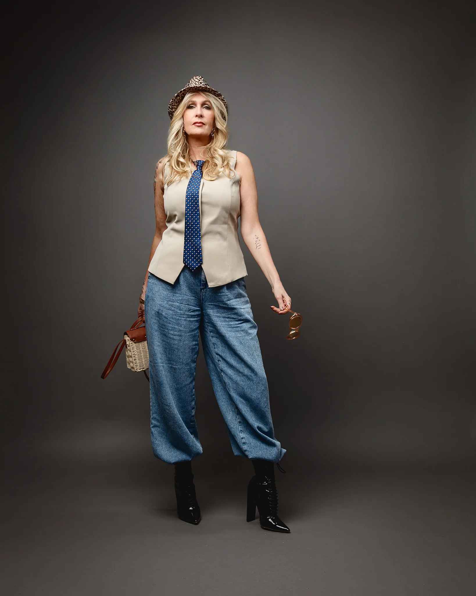 Woman in hat, tie and wide-leg jeans