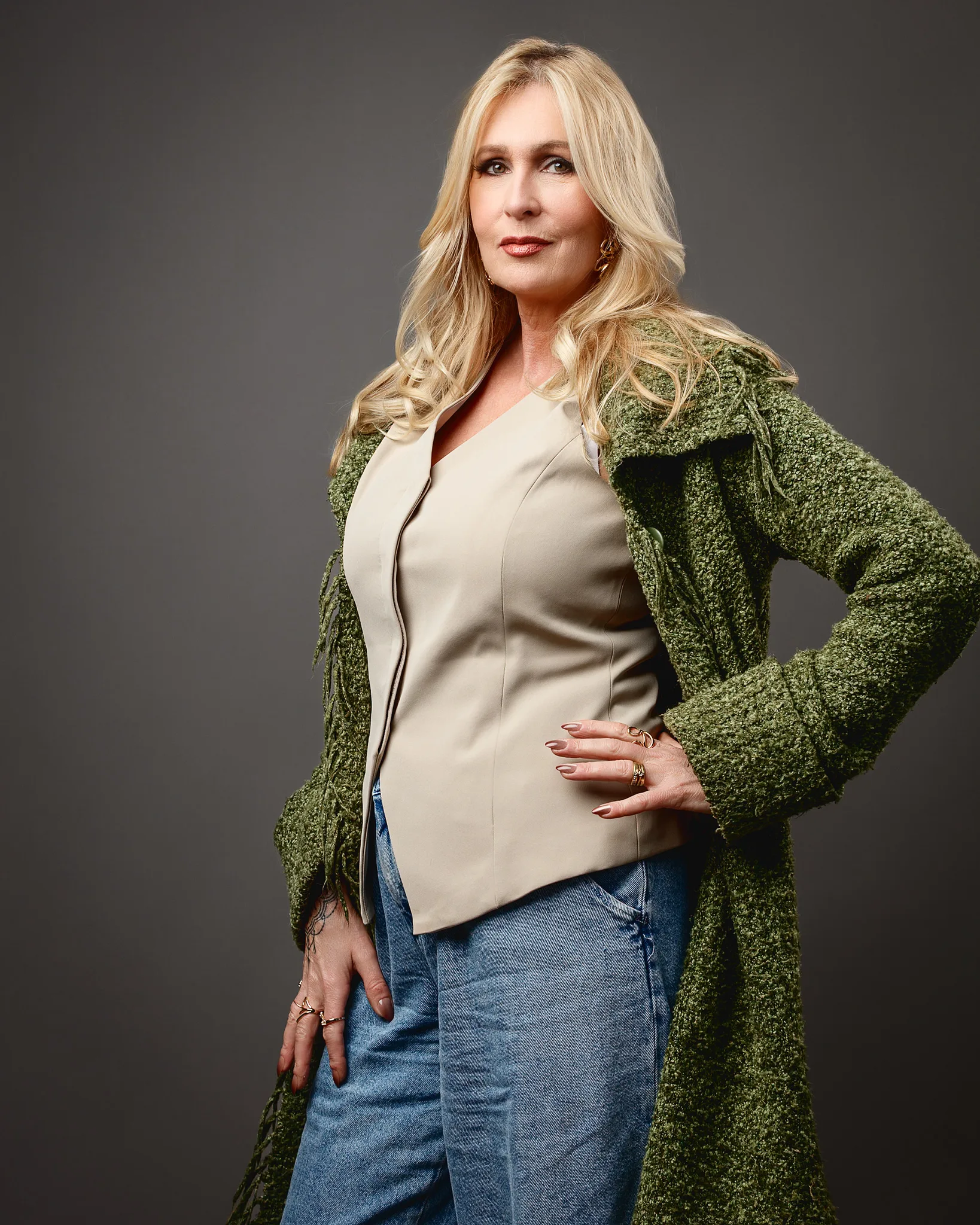 Confident blonde woman in green coat portrait