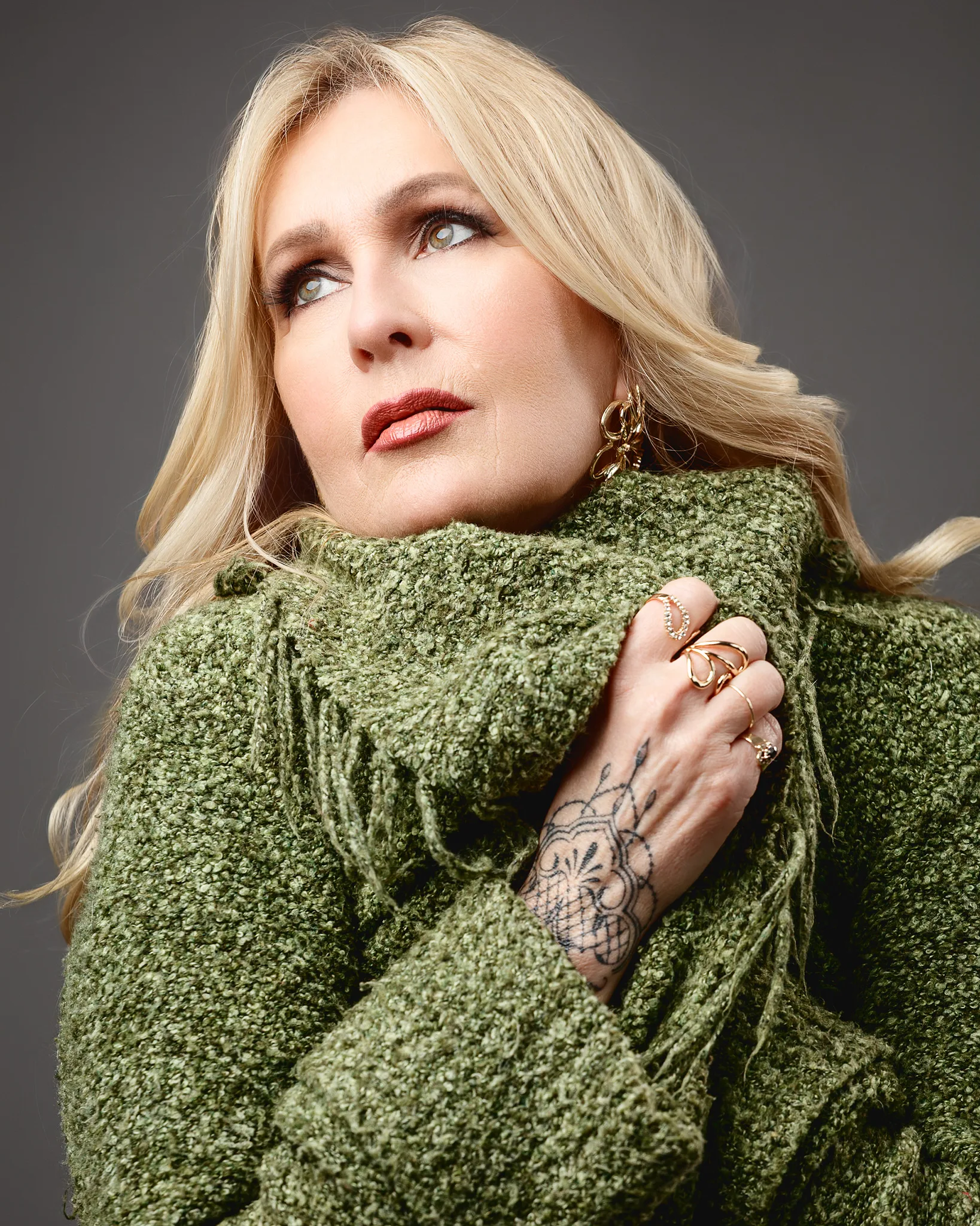Blonde woman in green knit jumper portrait