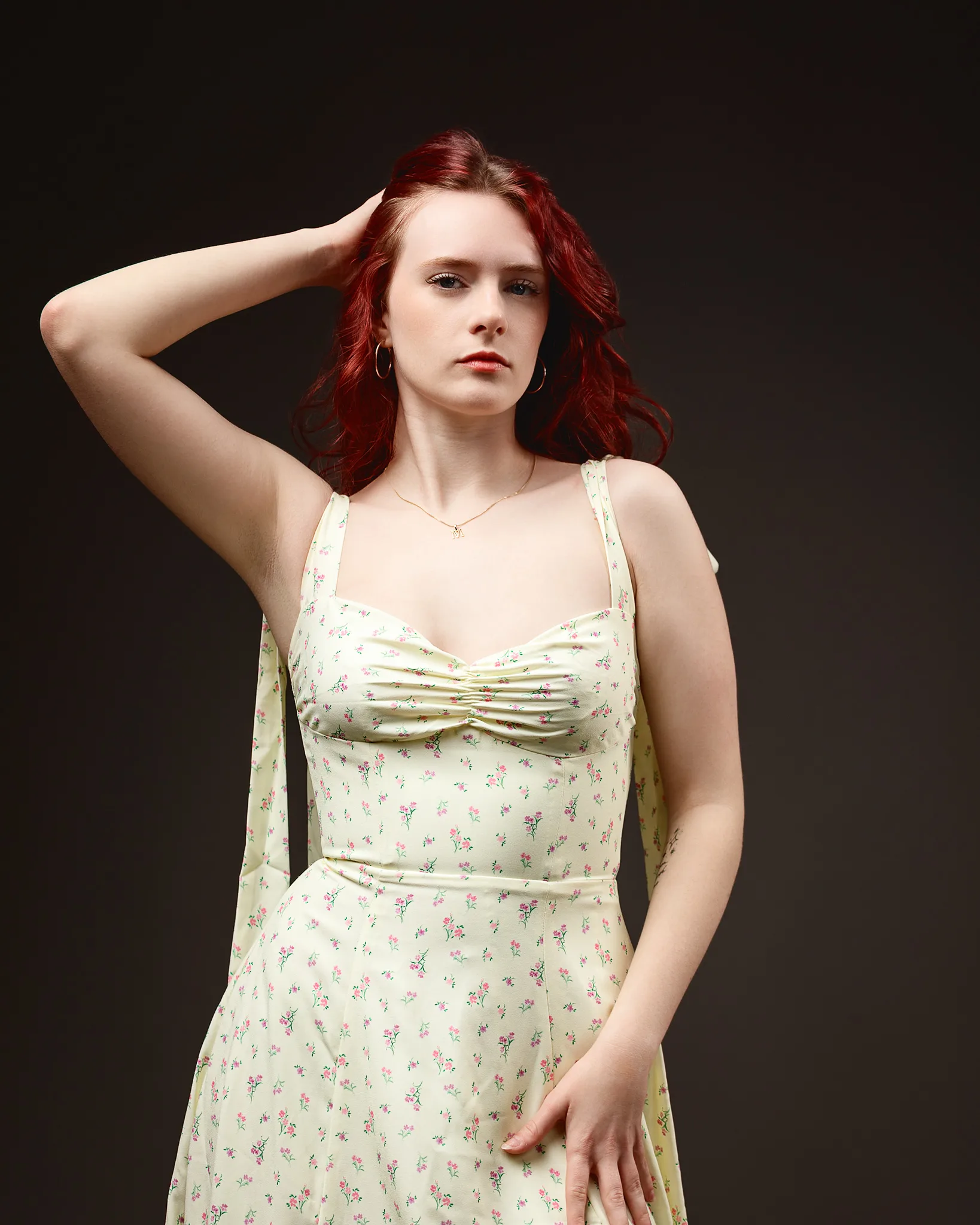 Red-haired woman in floral dress posing