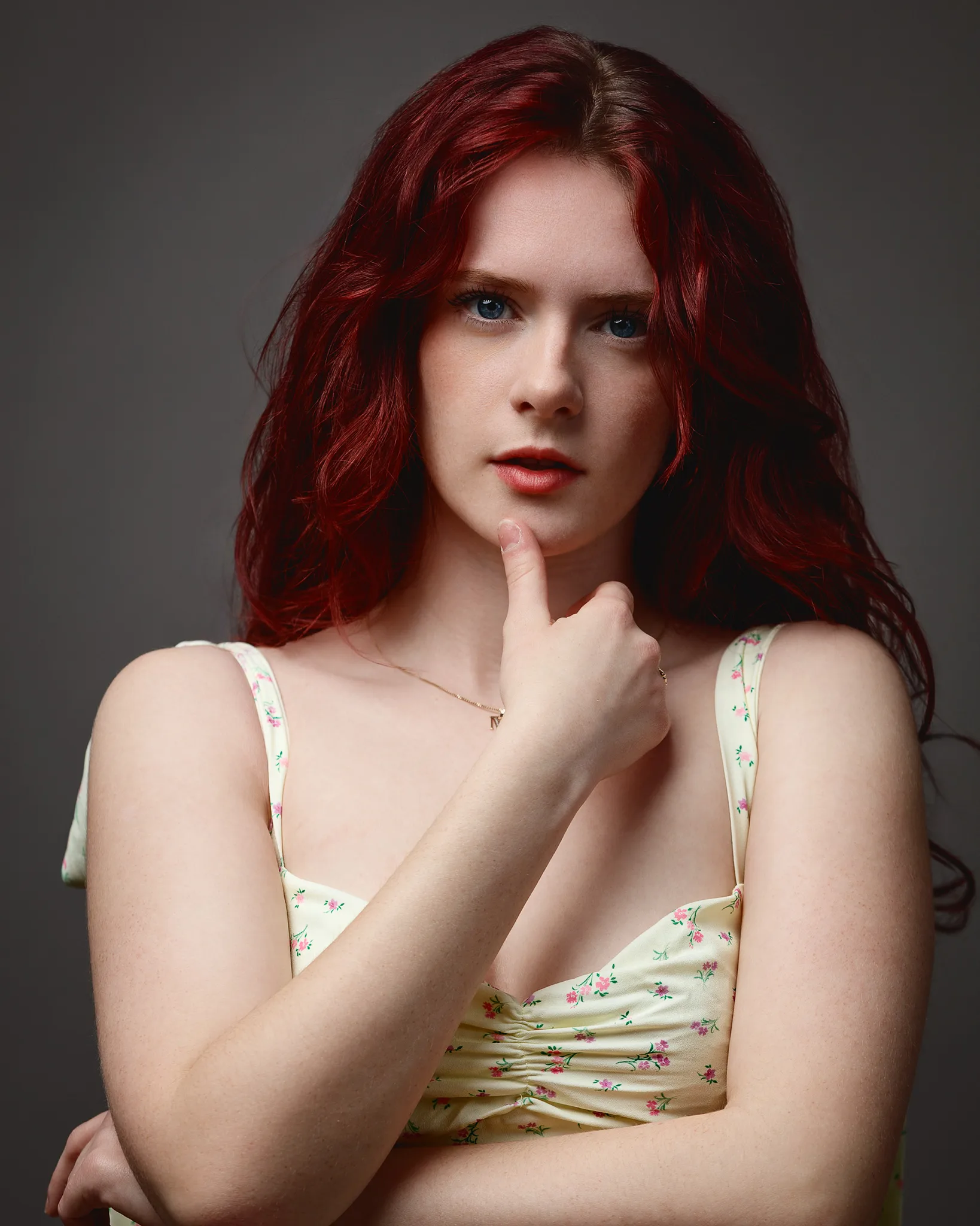 Red-haired woman posing with hand on chin