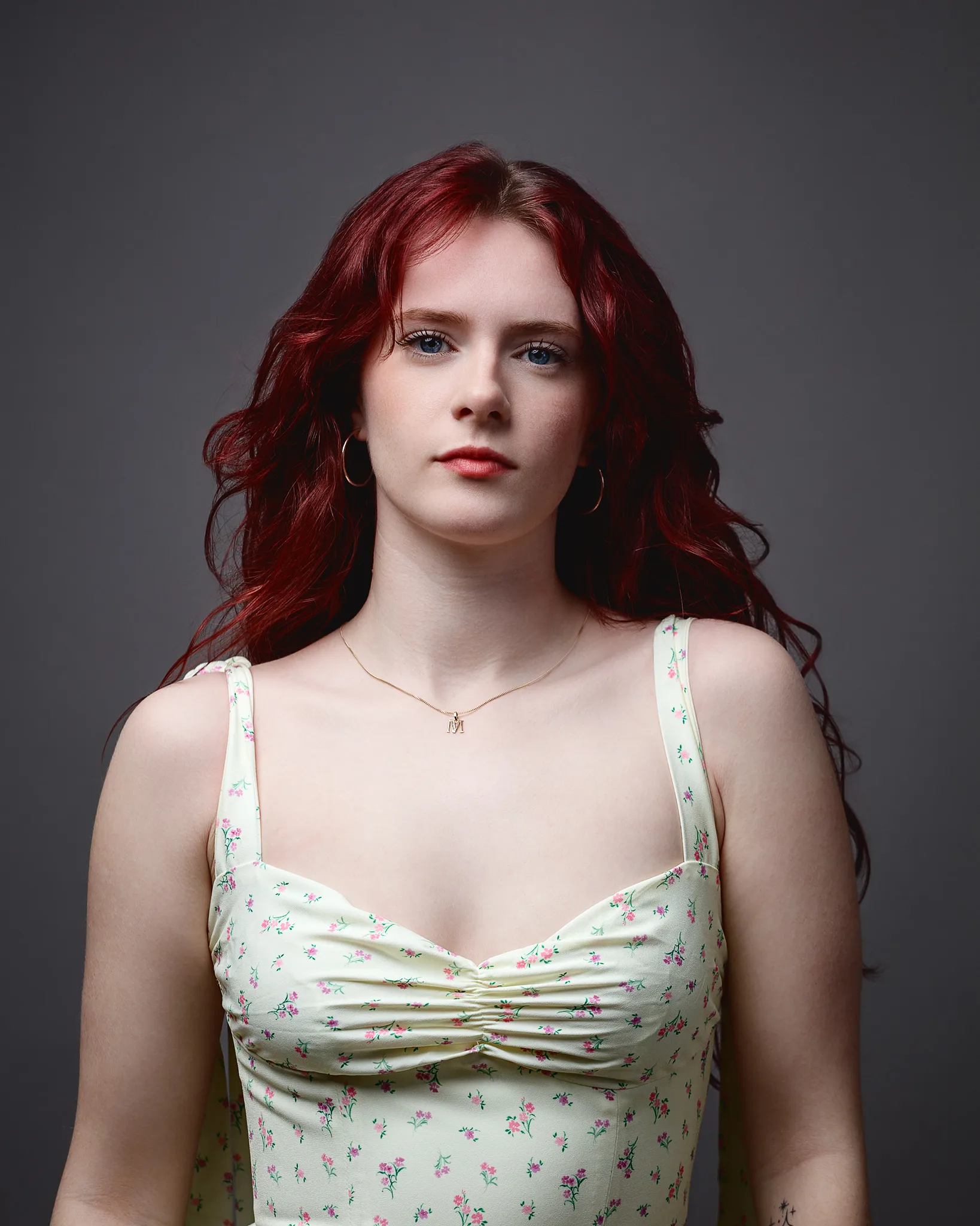 Portrait of red-haired woman against grey background
