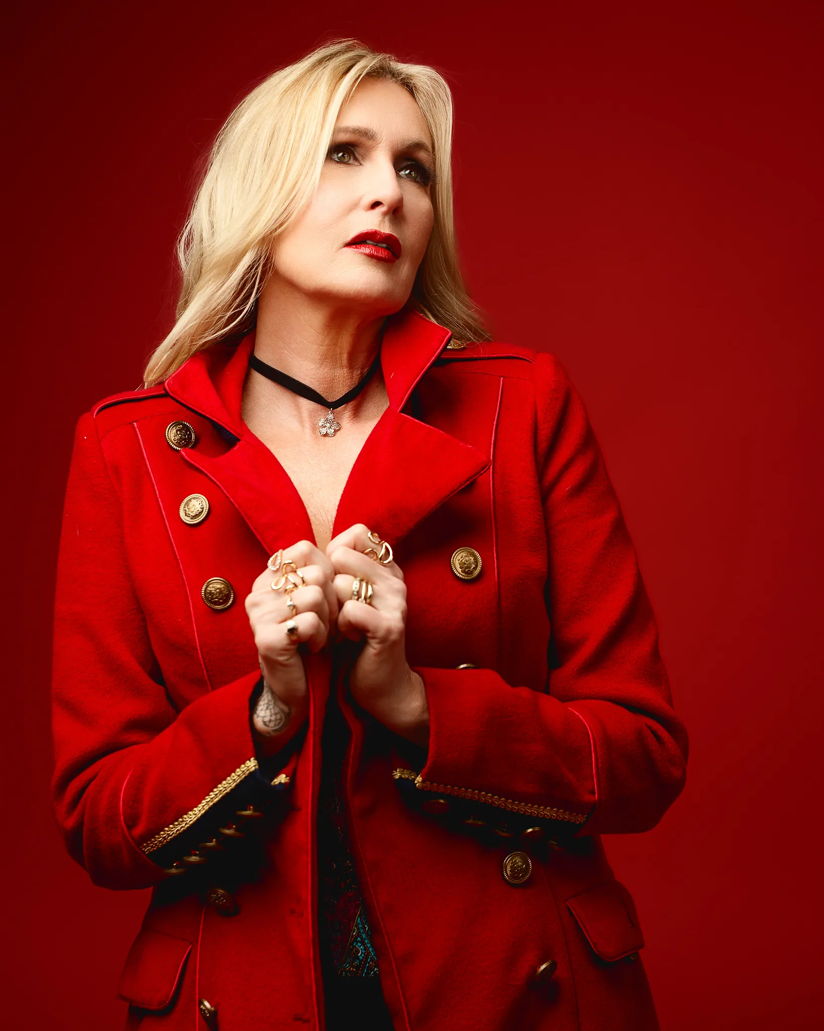 Blonde woman in red coat against red background