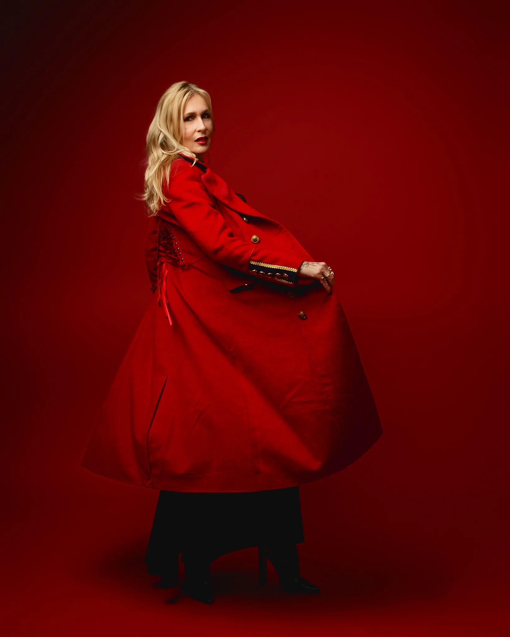 Woman in red coat against red background
