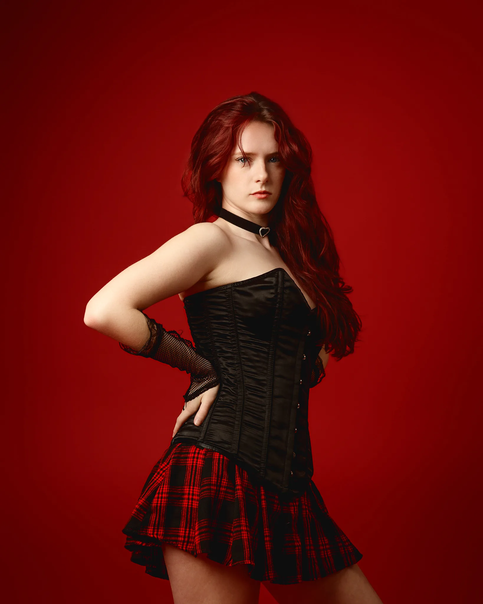 Red-haired woman in corset and tartan skirt