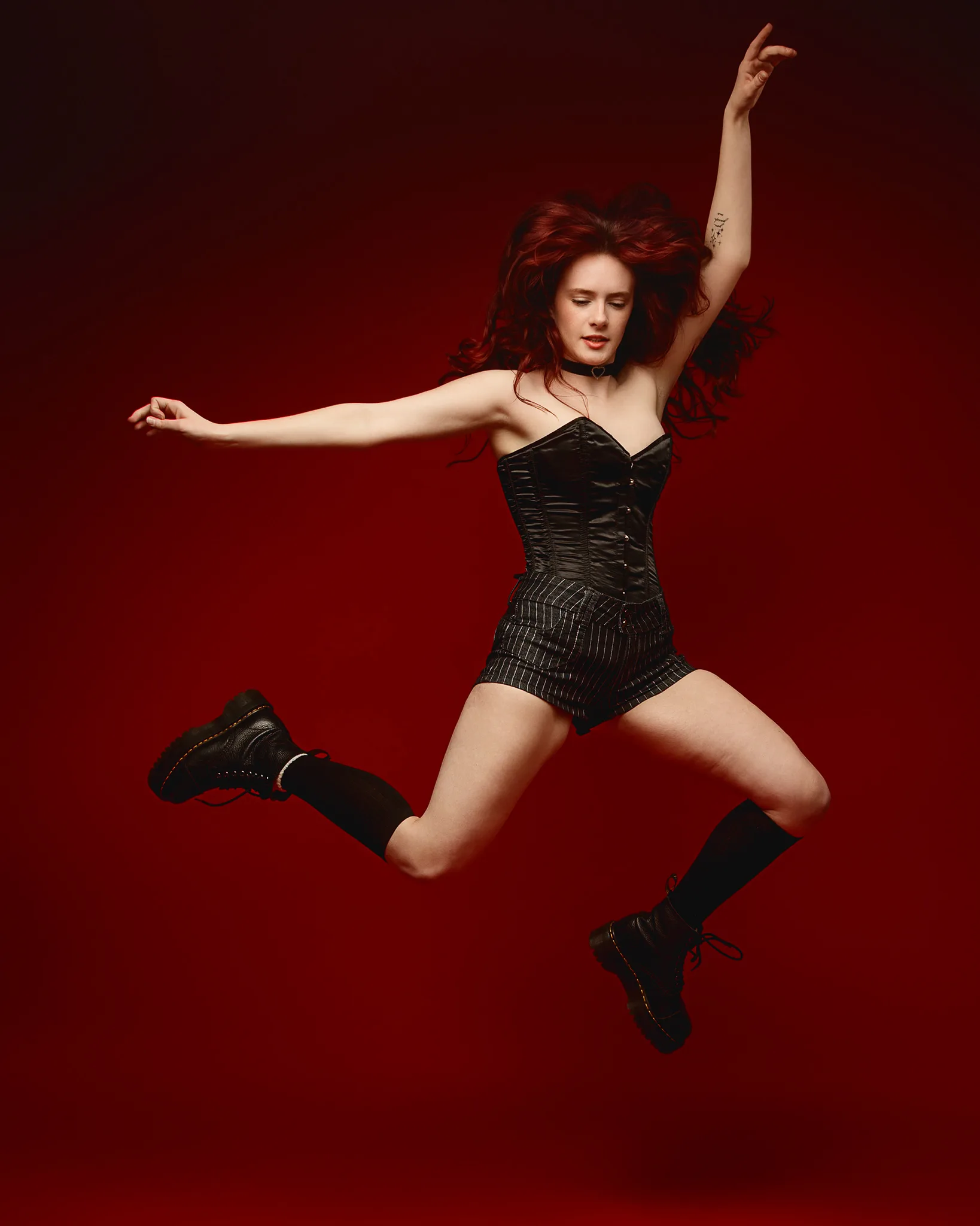 Woman jumping against bold red background