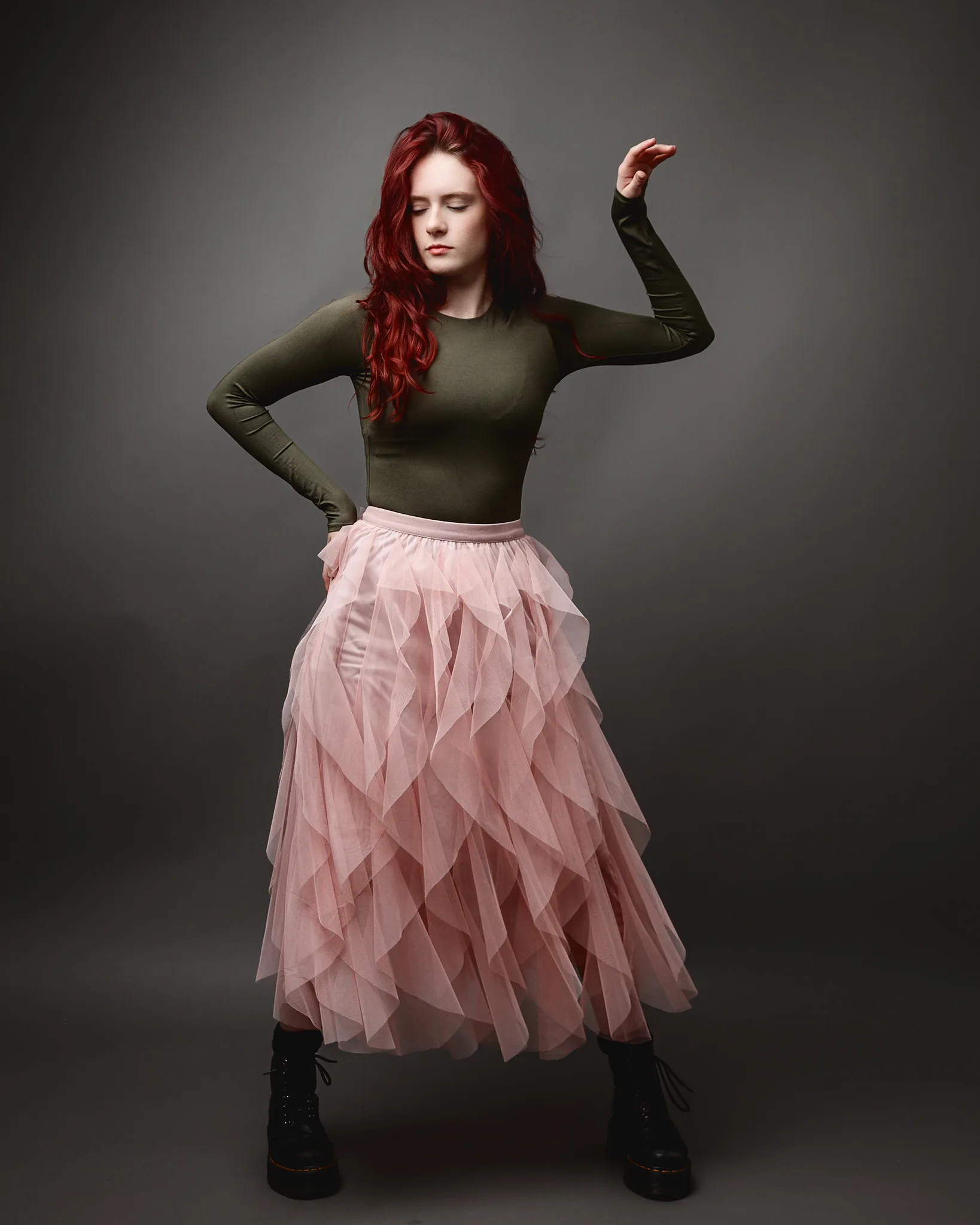 Red-haired woman in pink tulle skirt posing
