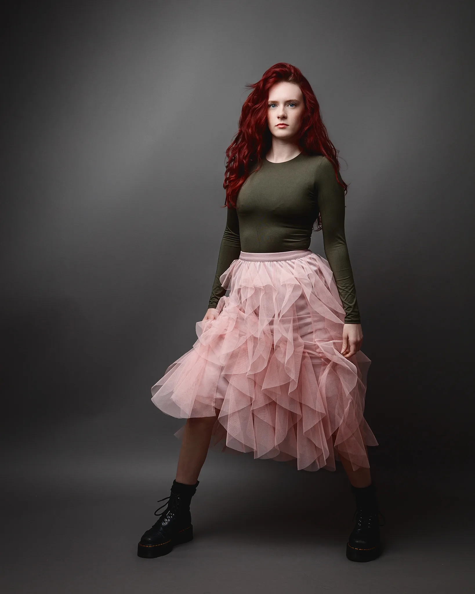 Red-haired woman in pink tulle skirt and boots