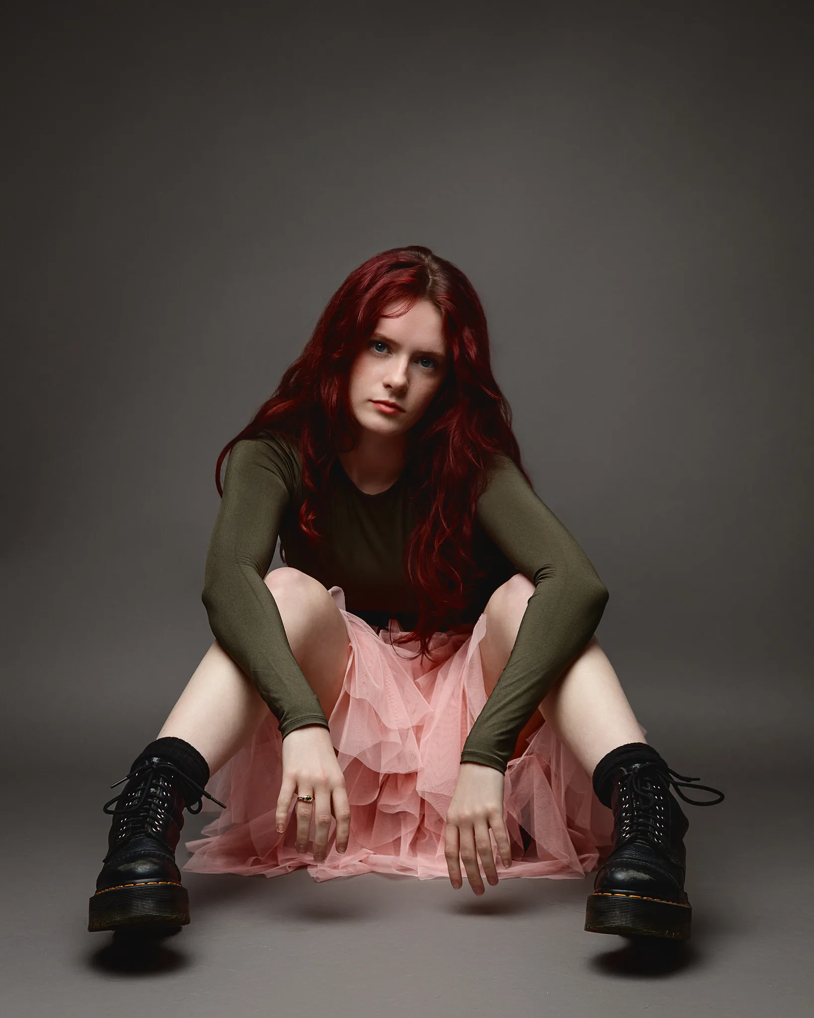 Red-haired woman in pink skirt and boots
