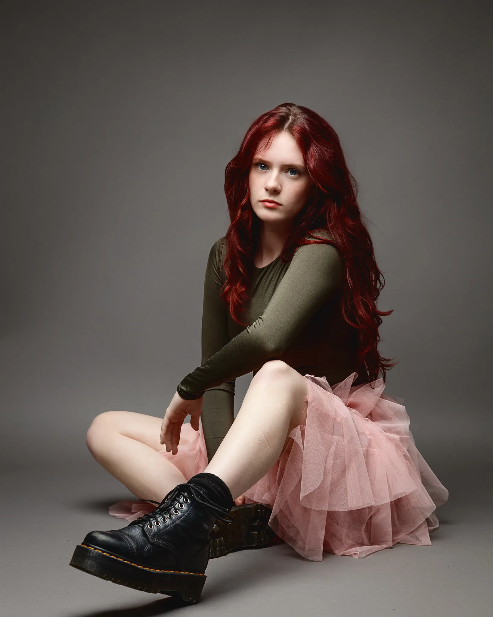 Red-haired woman in pink tulle skirt sitting