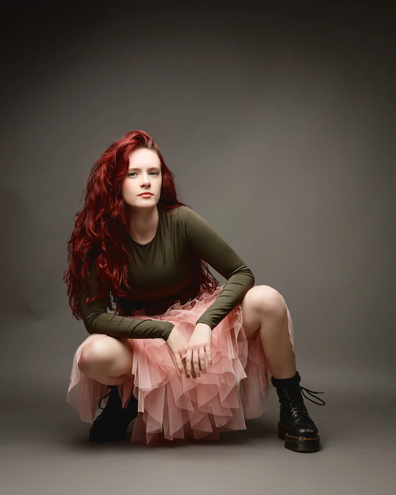 Red-haired woman in pink skirt and boots
