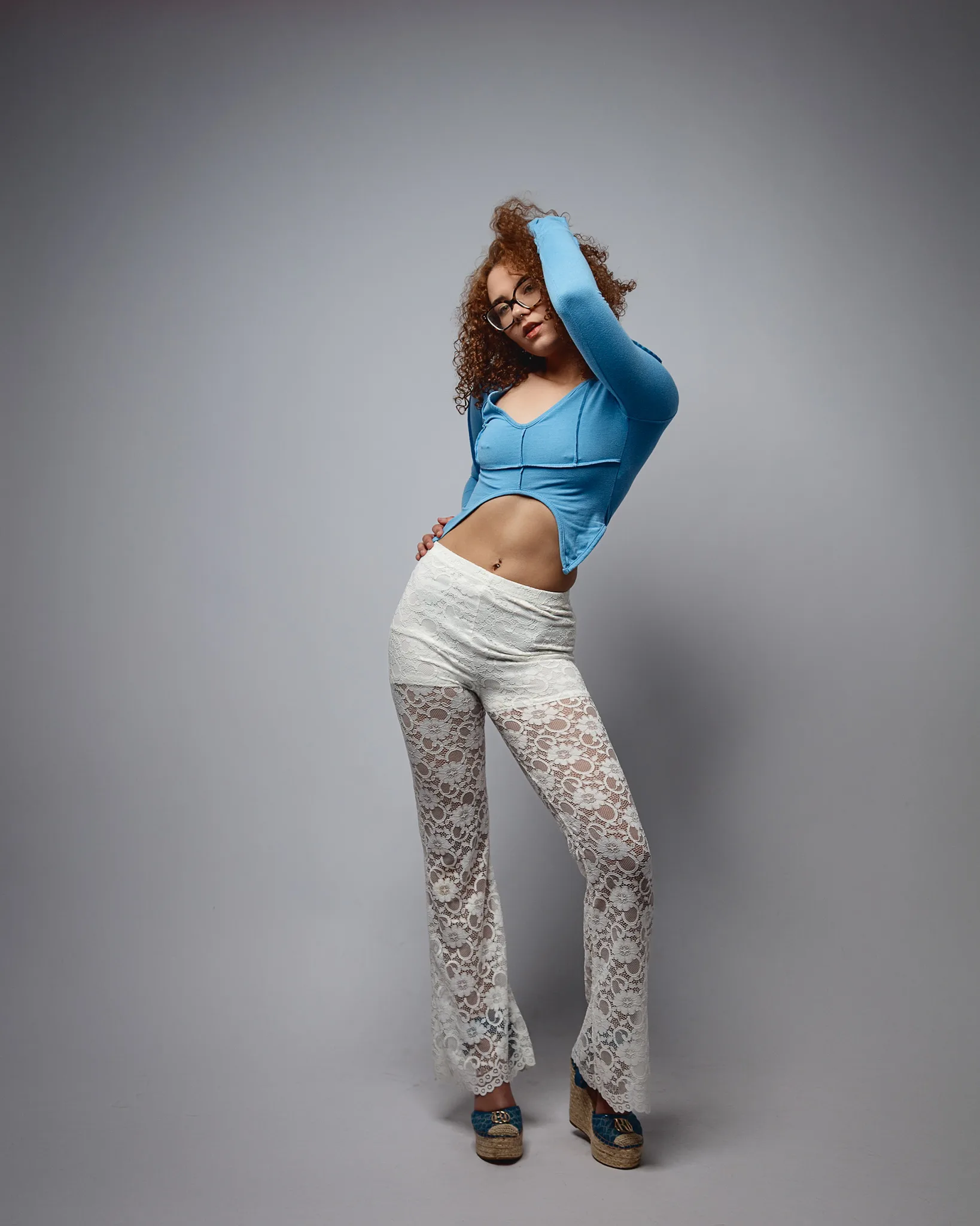 Woman posing in blue top and lace trousers