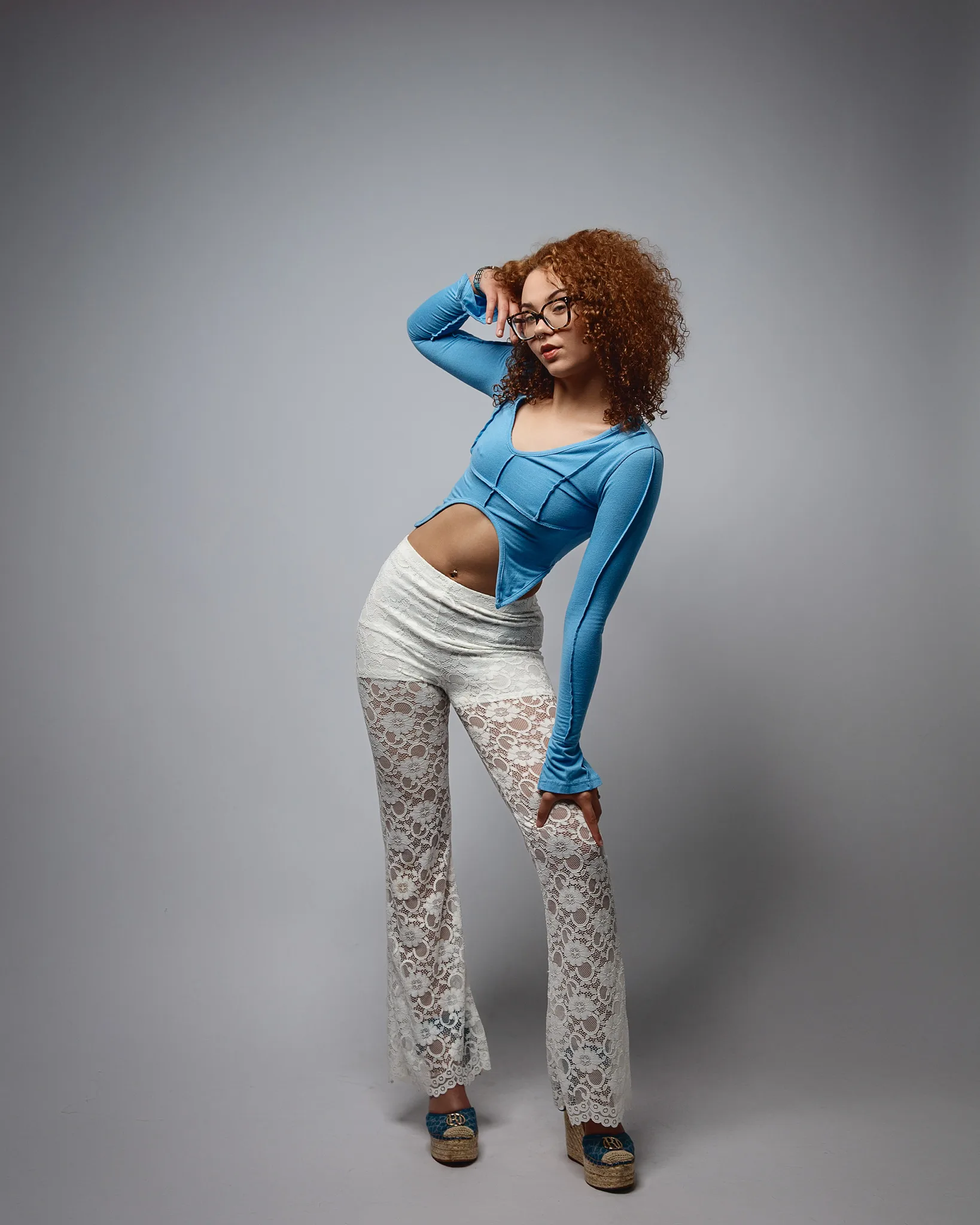 Woman posing in blue top and lace trousers
