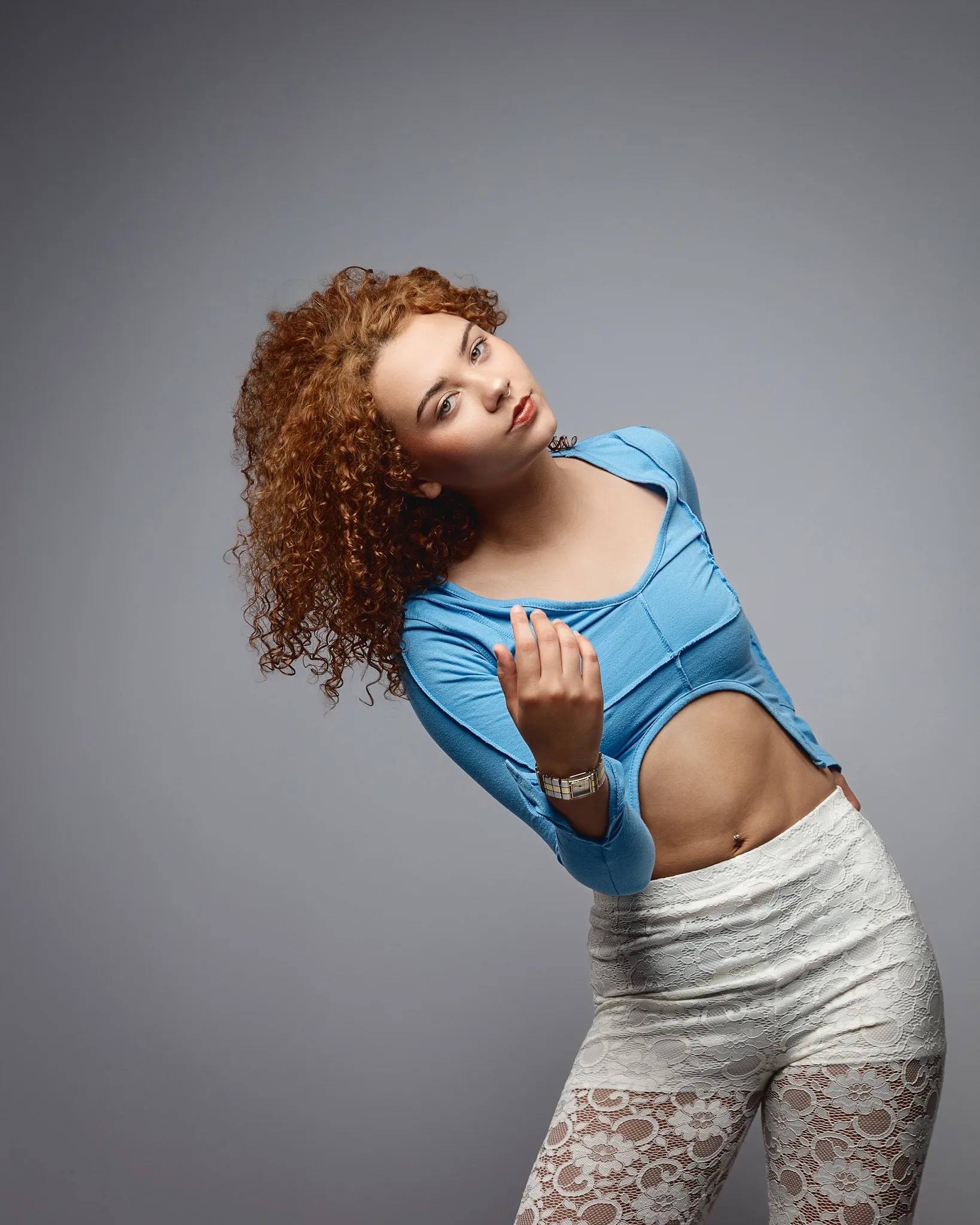 Woman with curly hair posing in studio