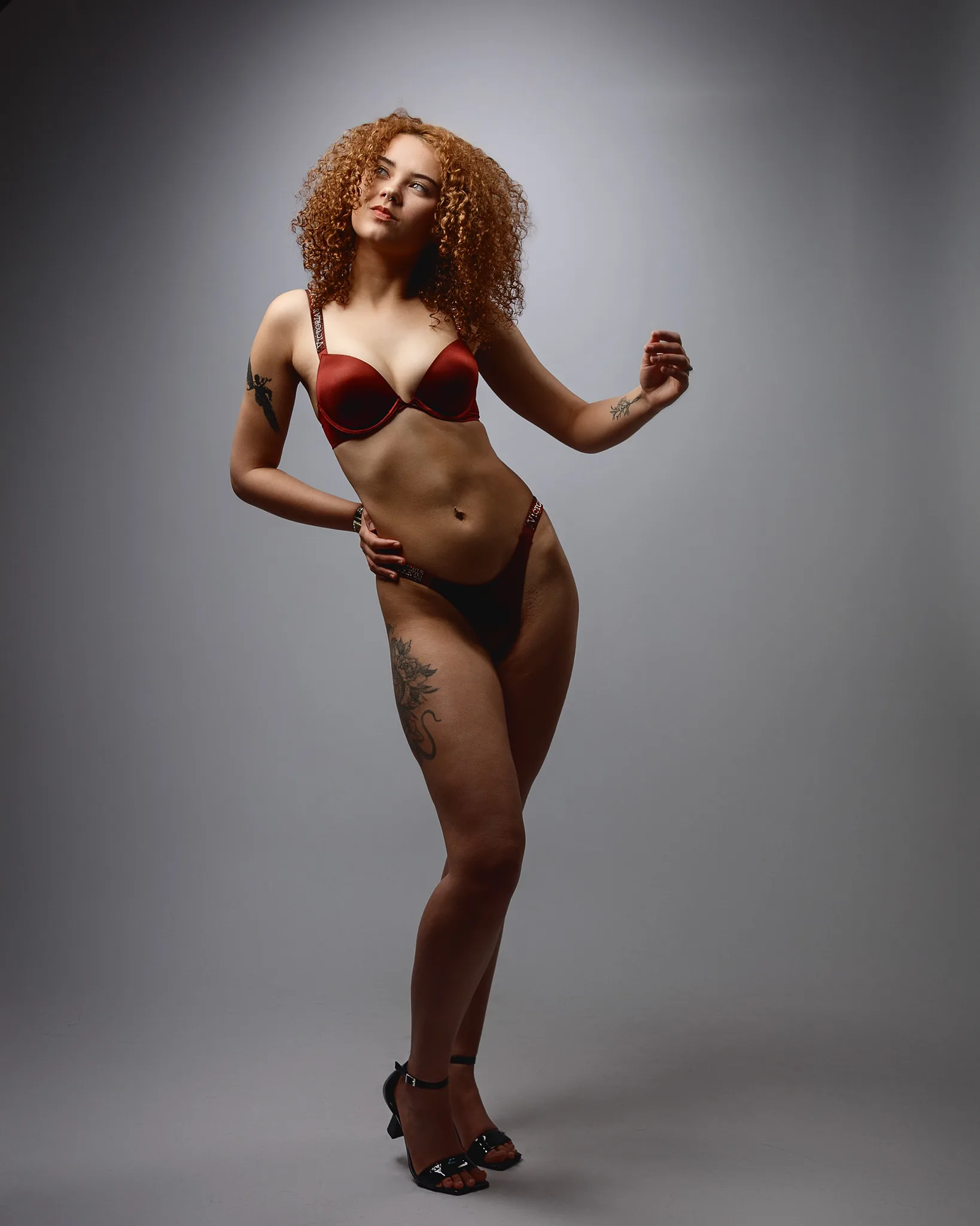 Woman with curly auburn hair wearing red bikini