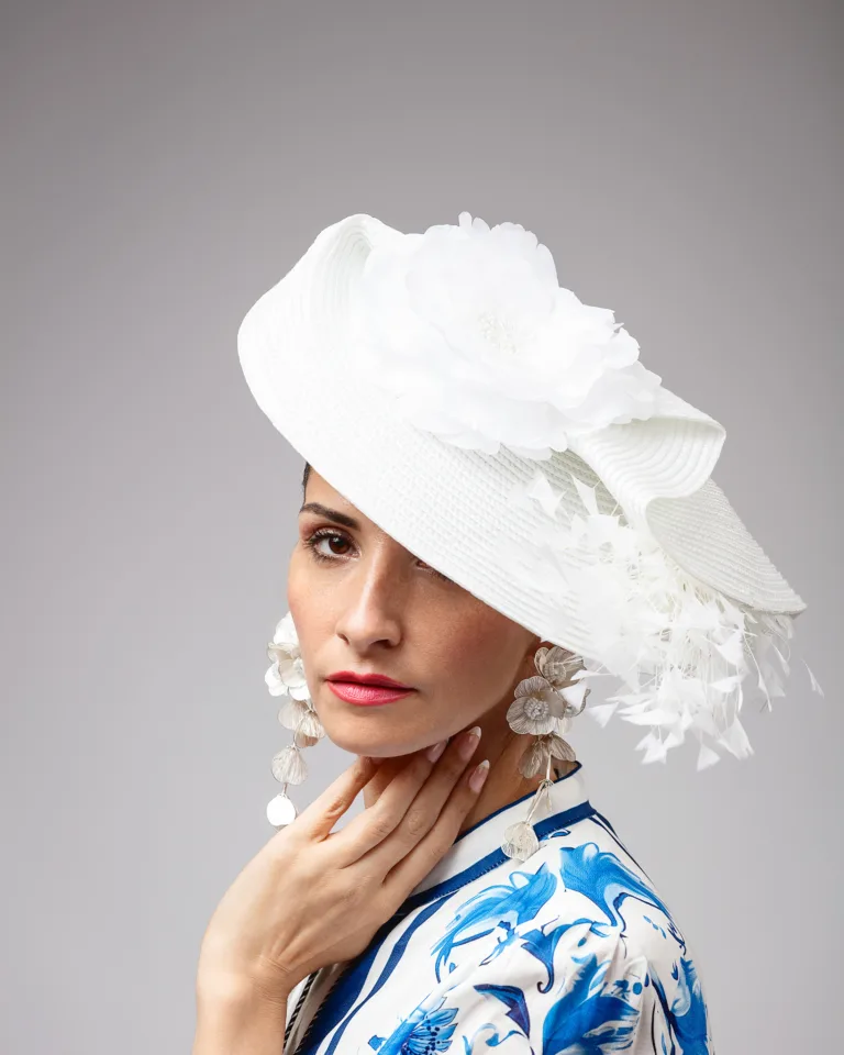 Woman wearing elegant white fascinator hat with feathers