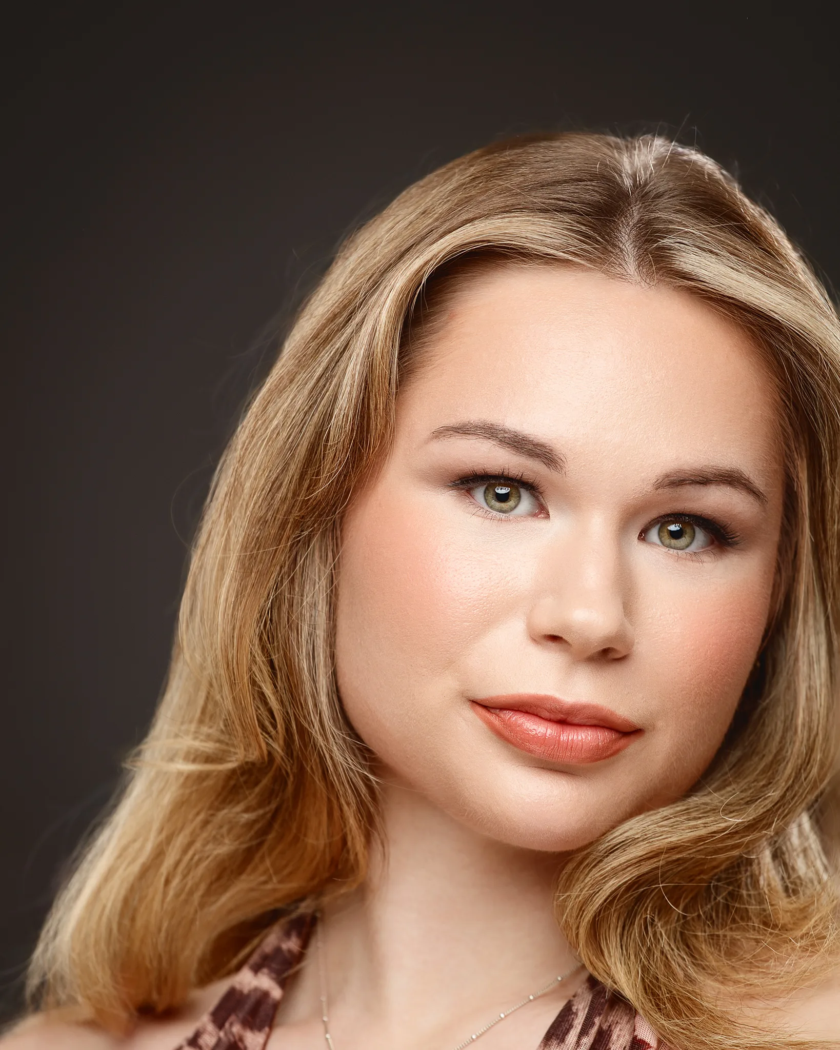 Professional portrait of woman with golden brown hair and green eyes