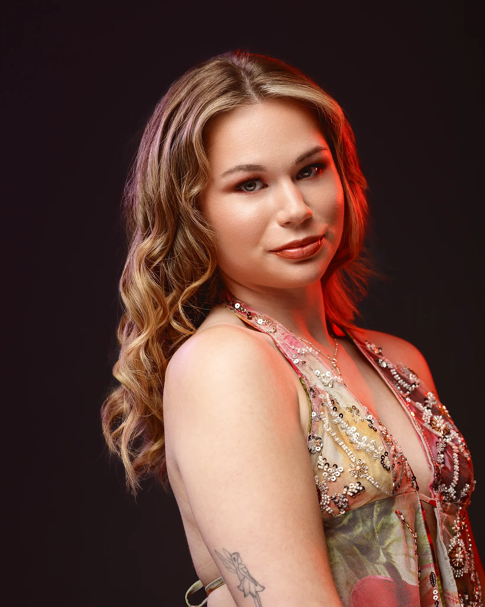 Woman with wavy blonde hair in sequined red dress portrait