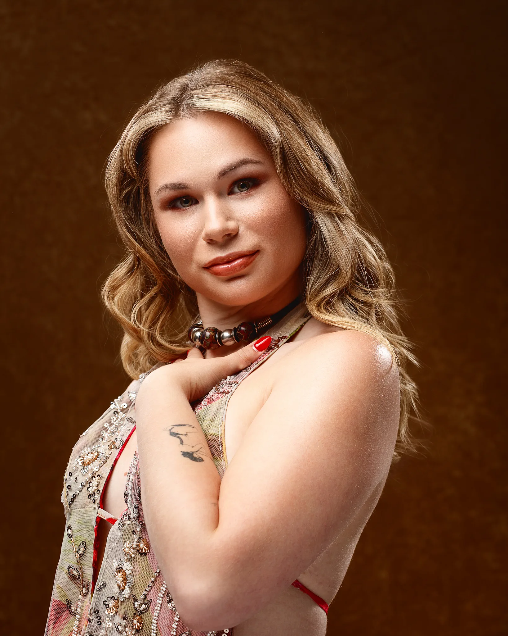 Woman with wavy blonde hair wearing embellished red dress