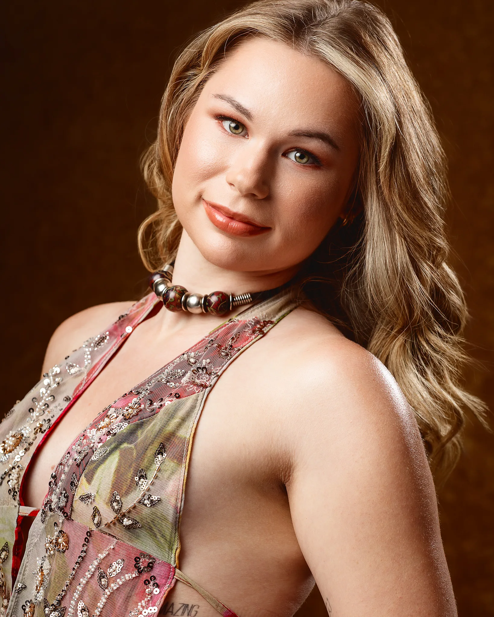 Woman with long blonde hair wearing embellished halter top