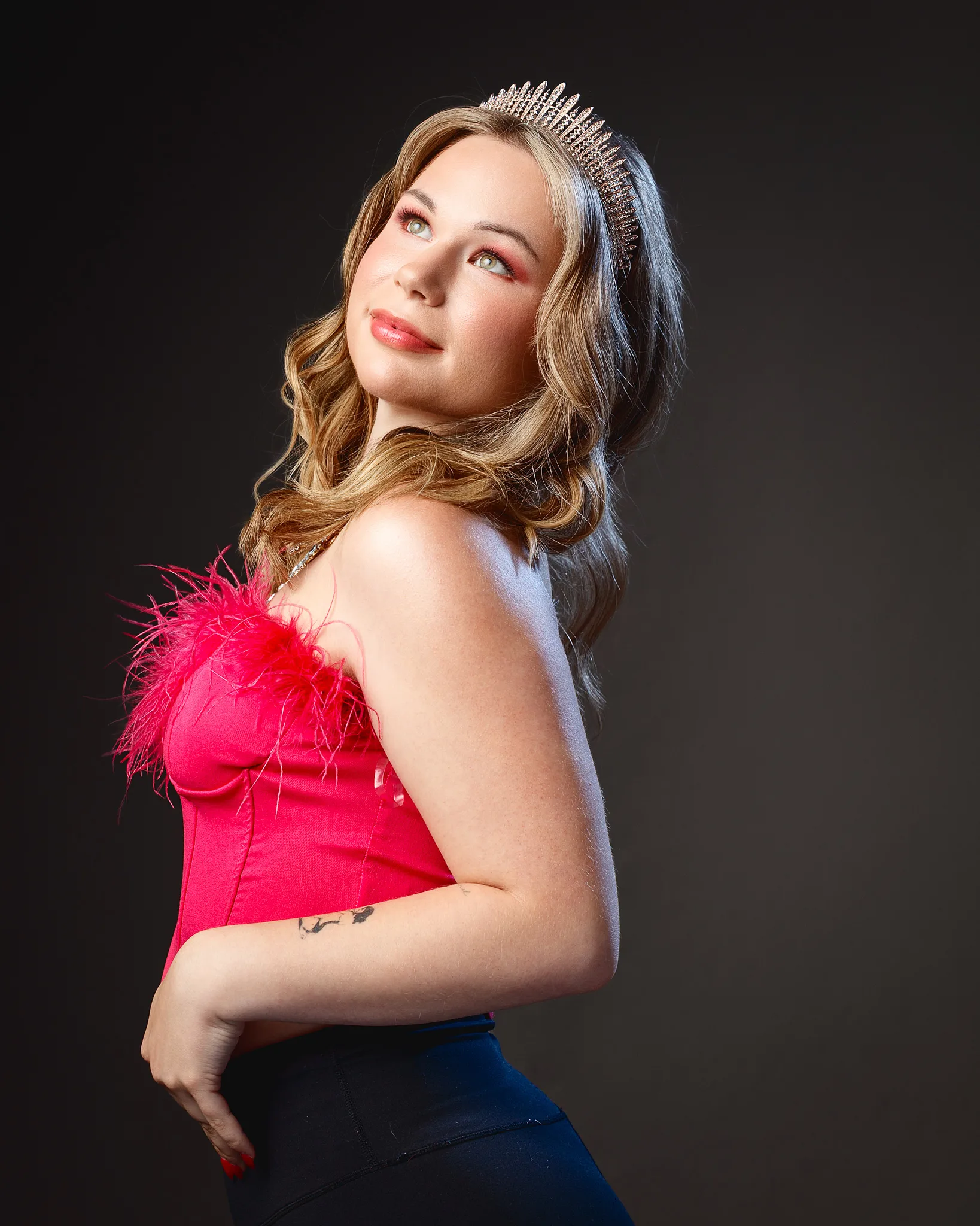 Woman wearing pink feathered corset top and tiara
