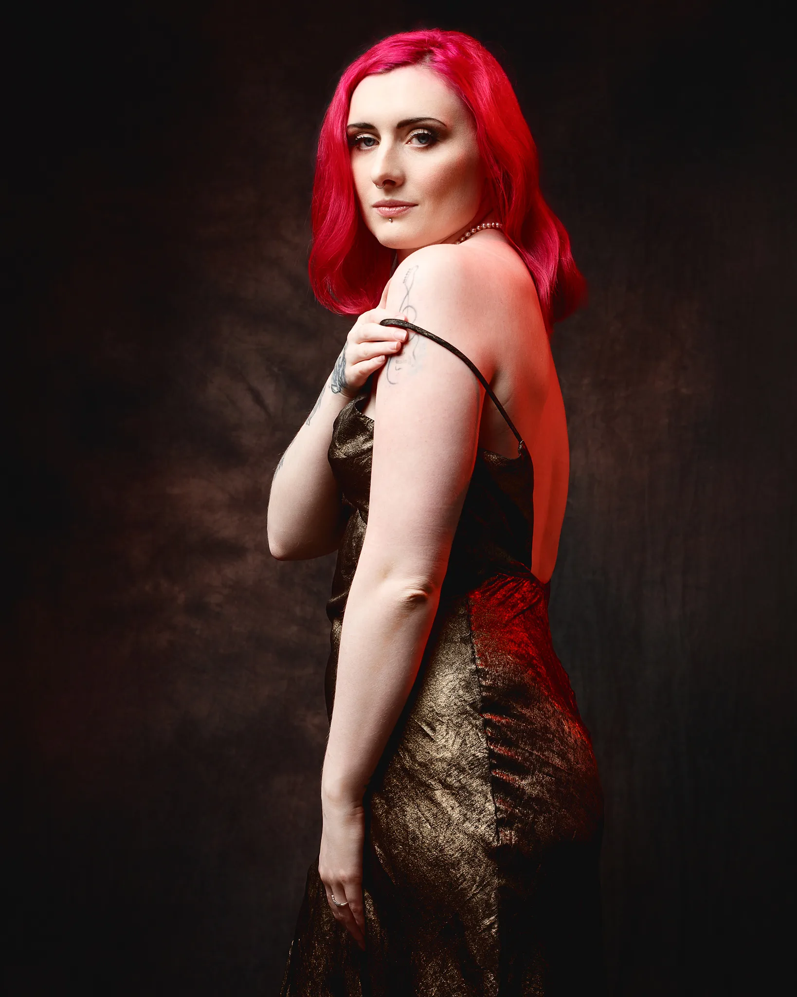 Woman with vibrant red hair wearing gold sequined dress