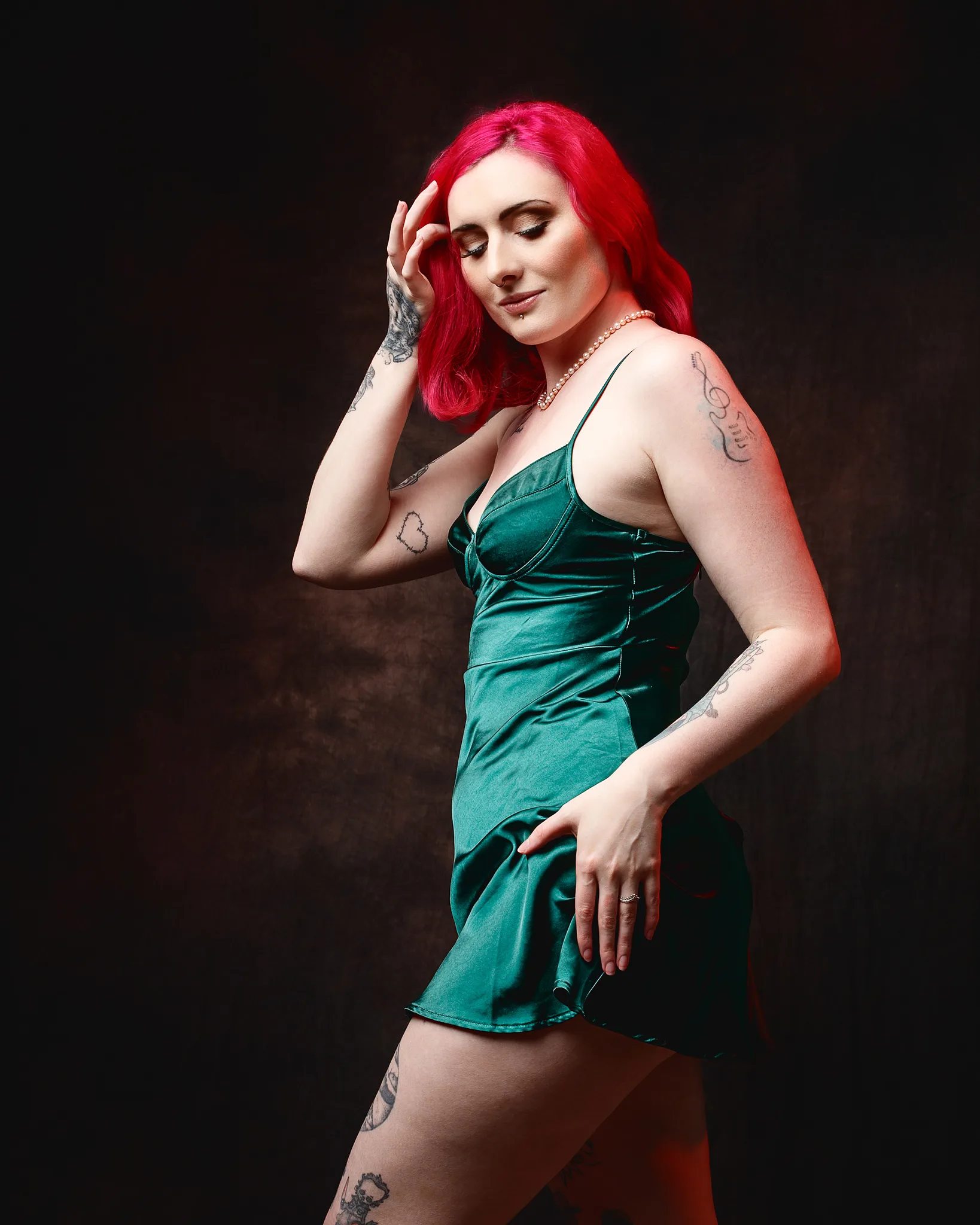 Woman with vibrant red hair wearing teal velvet dress