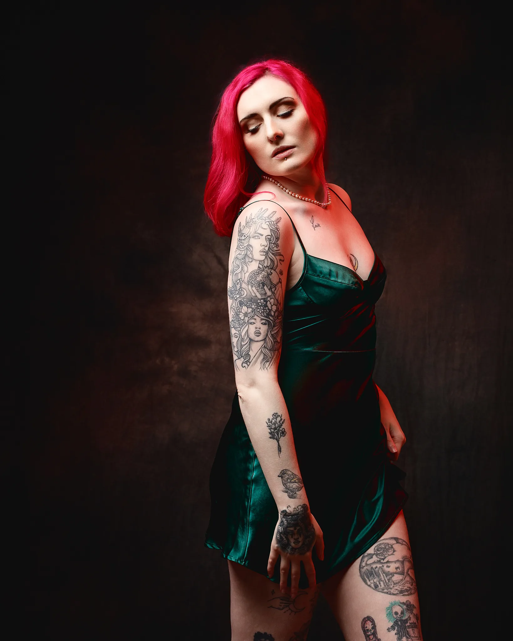 Woman with vibrant pink hair and full sleeve tattoos