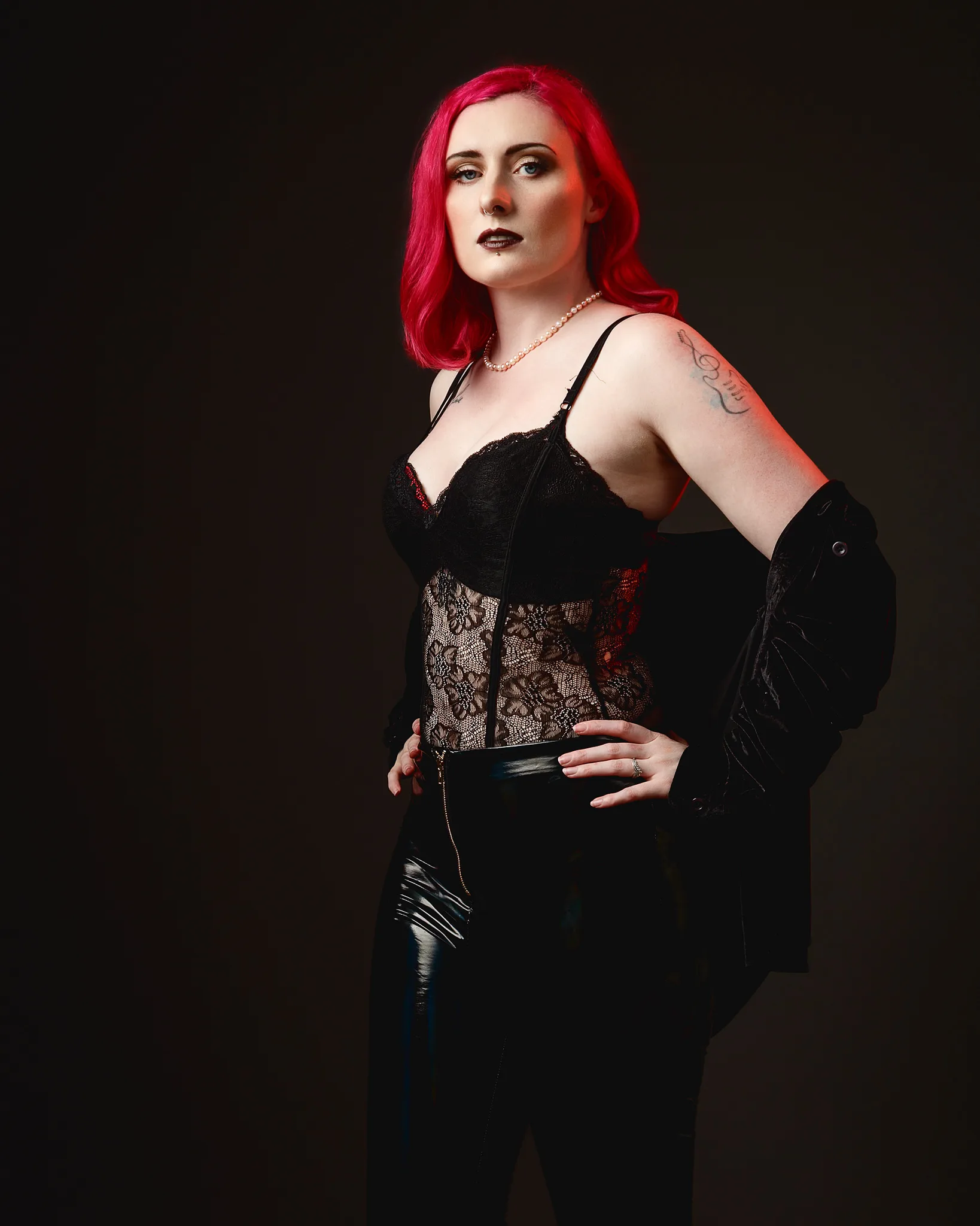 Woman with vibrant red hair wearing black gothic corset outfit