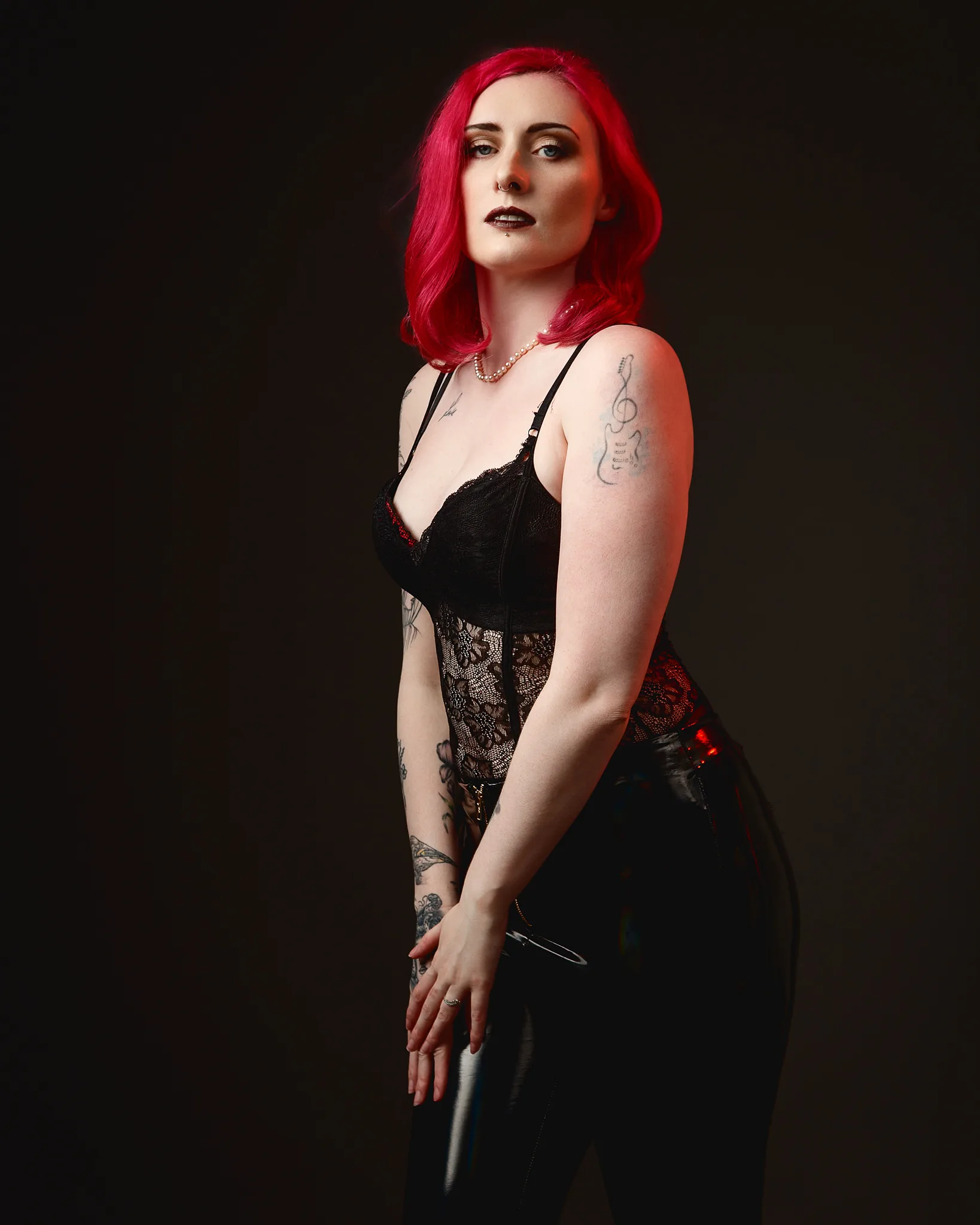 Woman with vibrant red hair wearing black lace corset