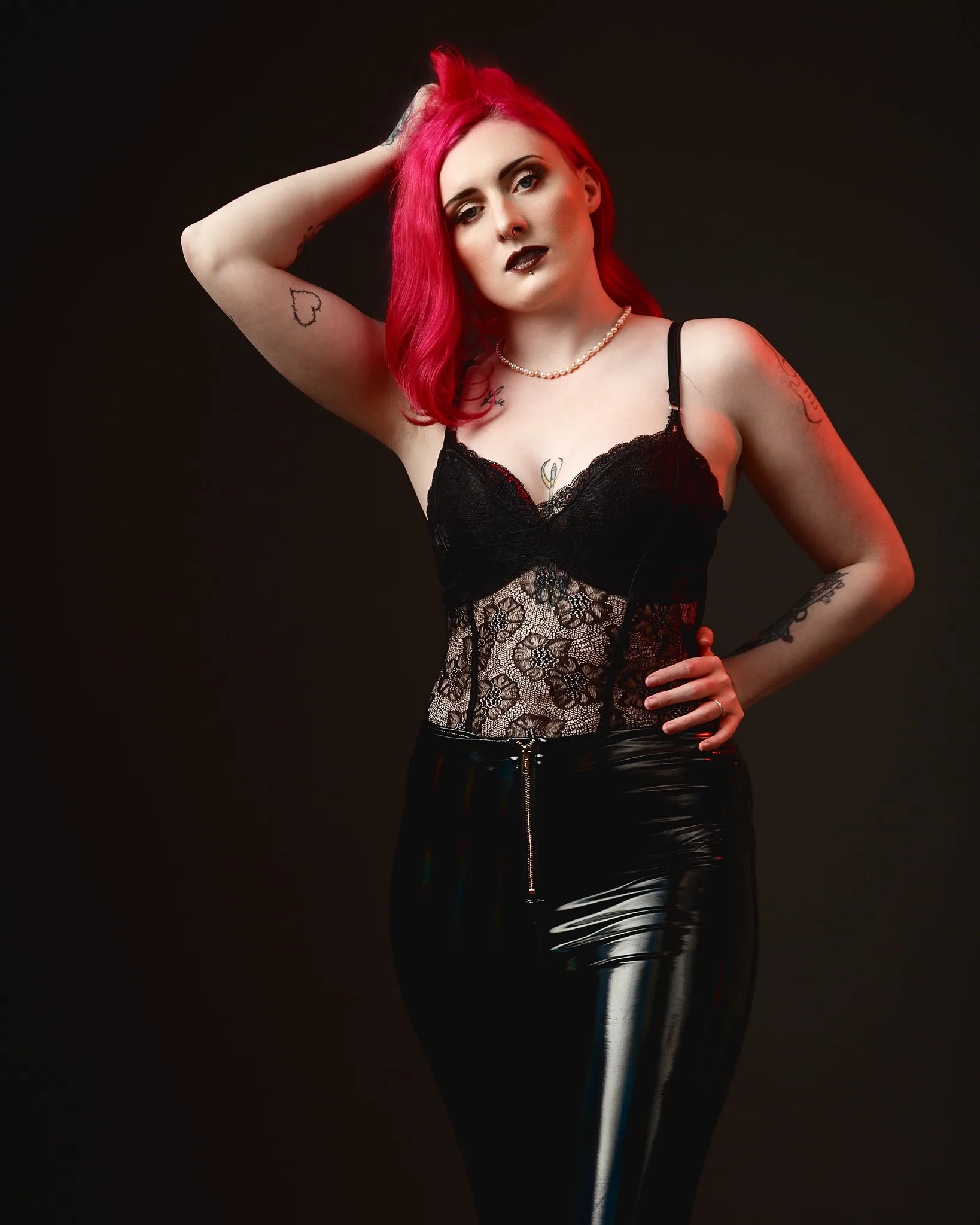 Woman with bright red hair wearing black lace corset top