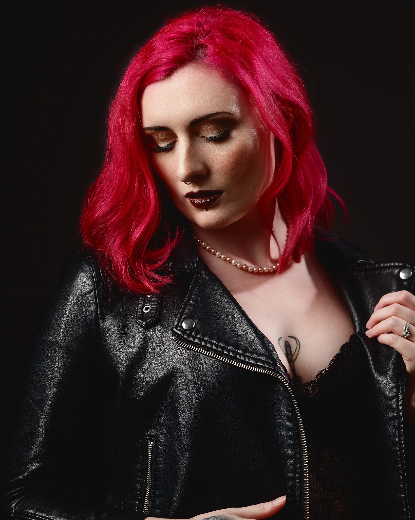 Woman with vibrant red hair wearing black leather jacket