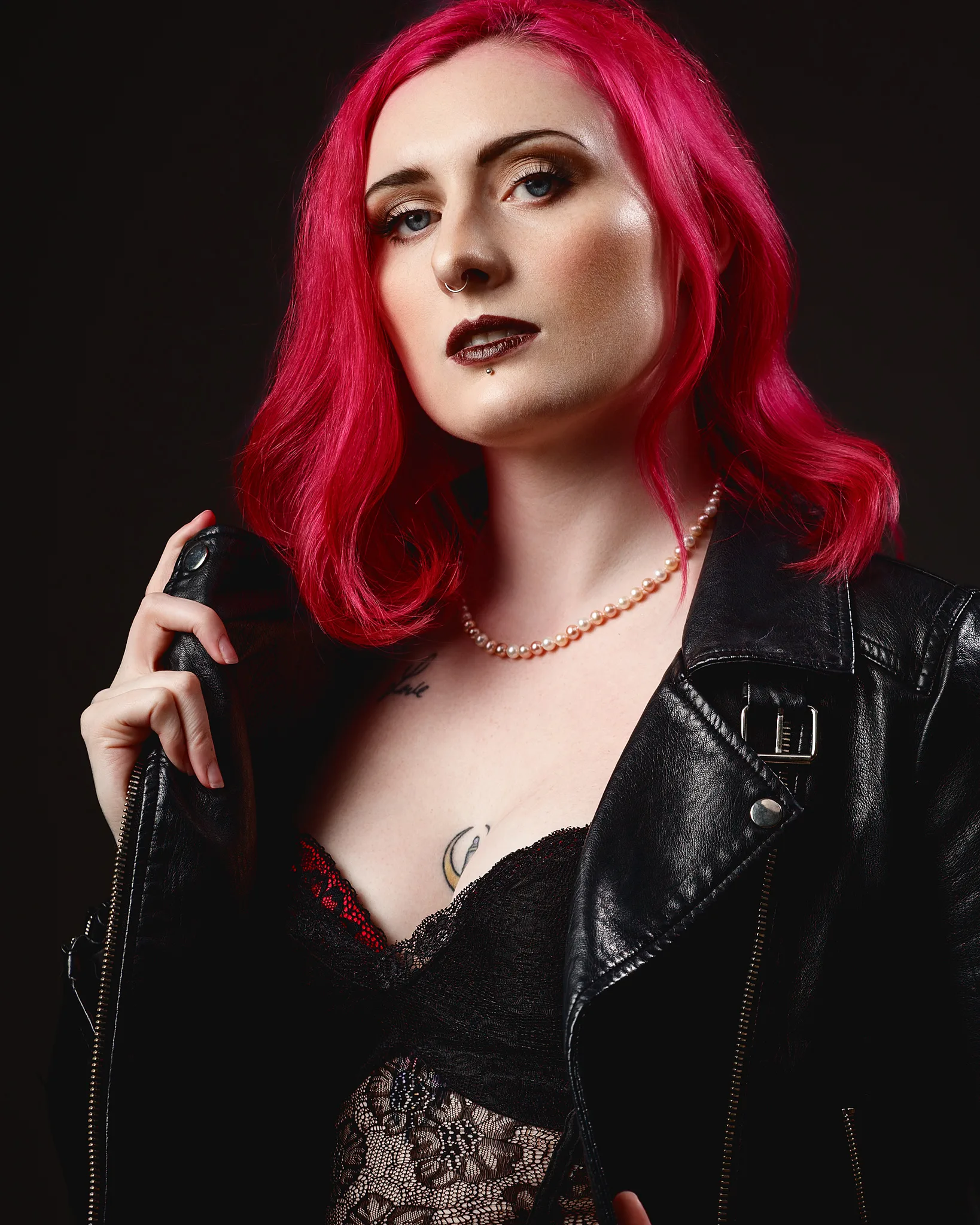 Woman with vibrant pink hair wearing black leather jacket