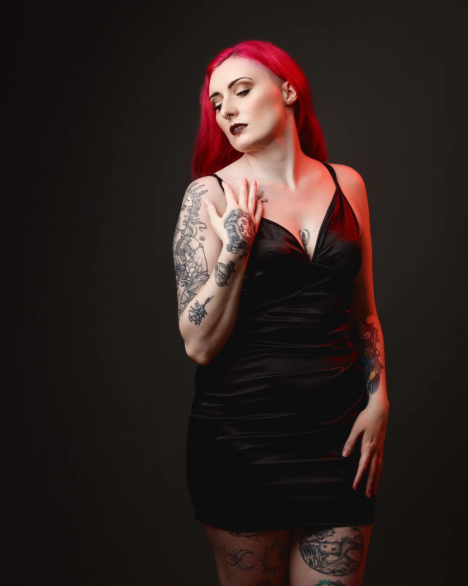Woman with vibrant red hair and extensive body tattoos