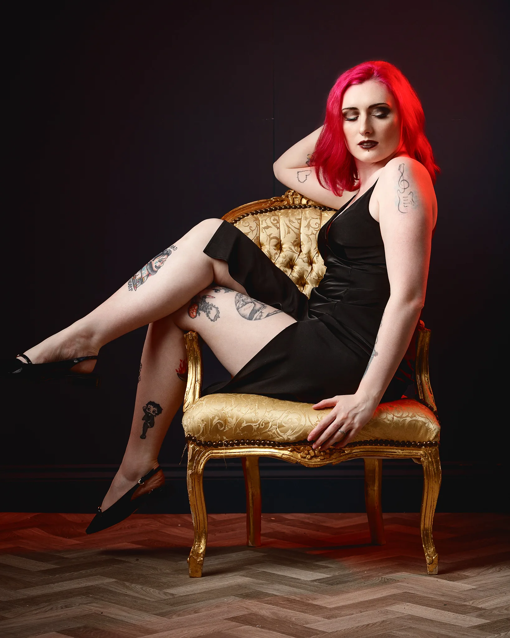 Woman with red hair sitting on ornate gold chair
