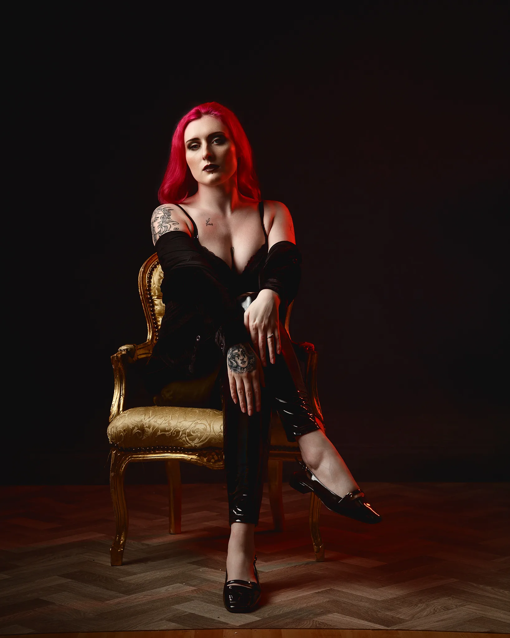 Woman with bright red hair sitting on ornate gold chair
