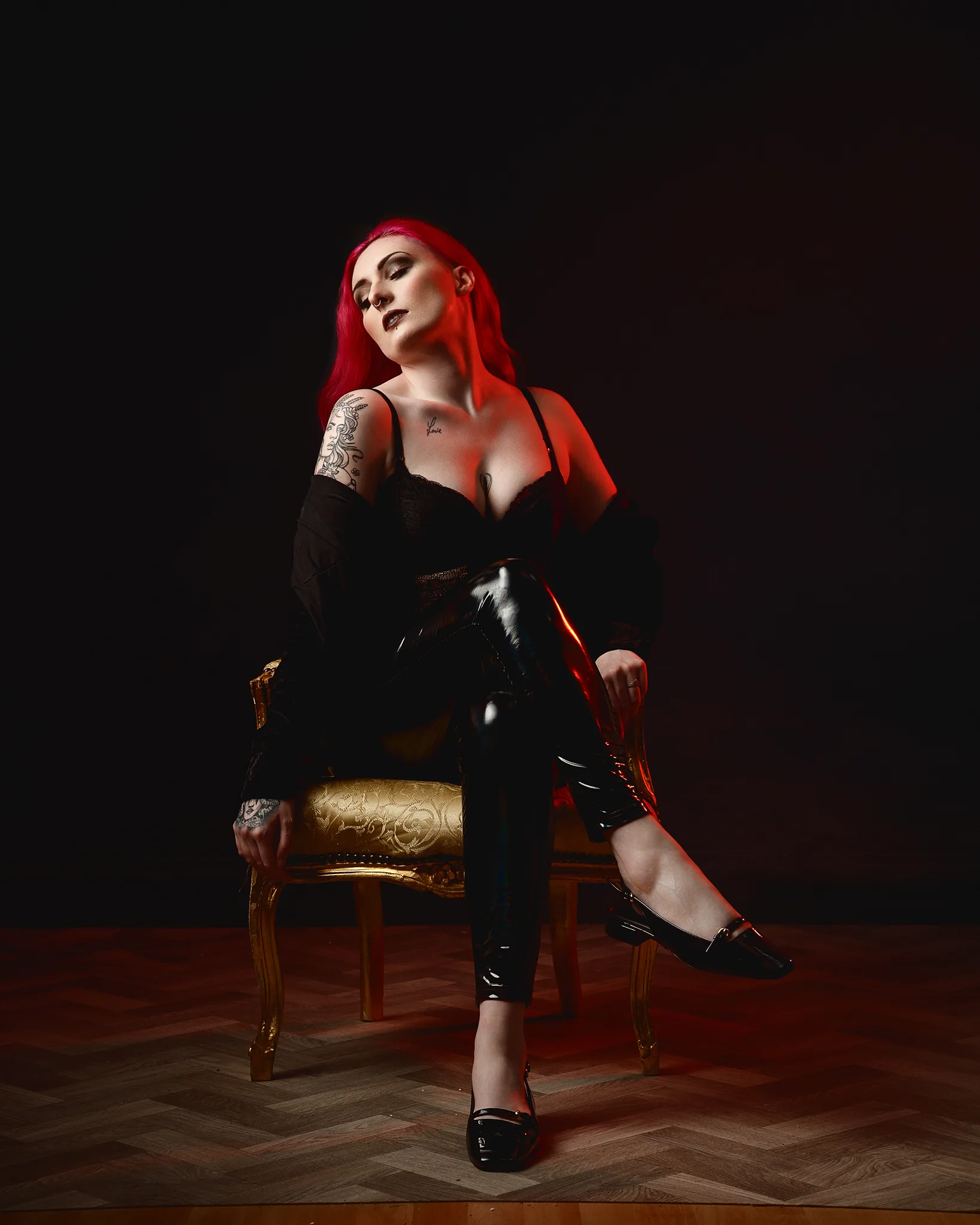 Woman with bright red hair sitting on ornate gold chair