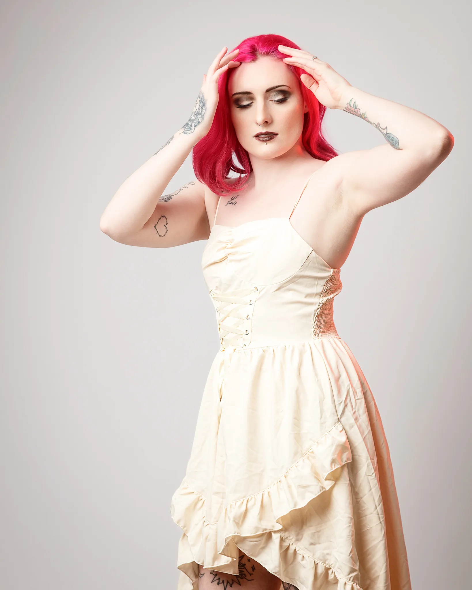 Woman with vibrant red hair wearing cream corset dress