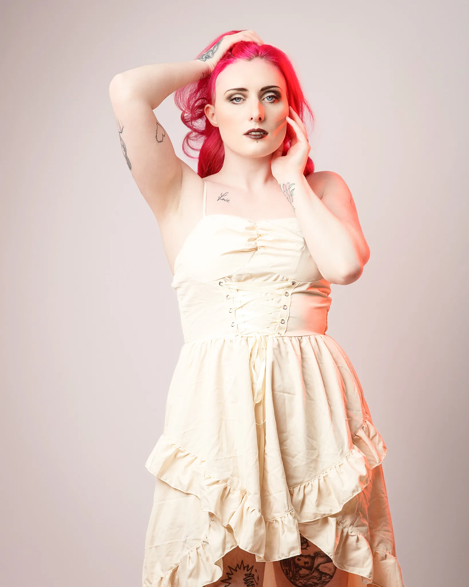 Woman with vibrant pink hair wearing cream corset dress