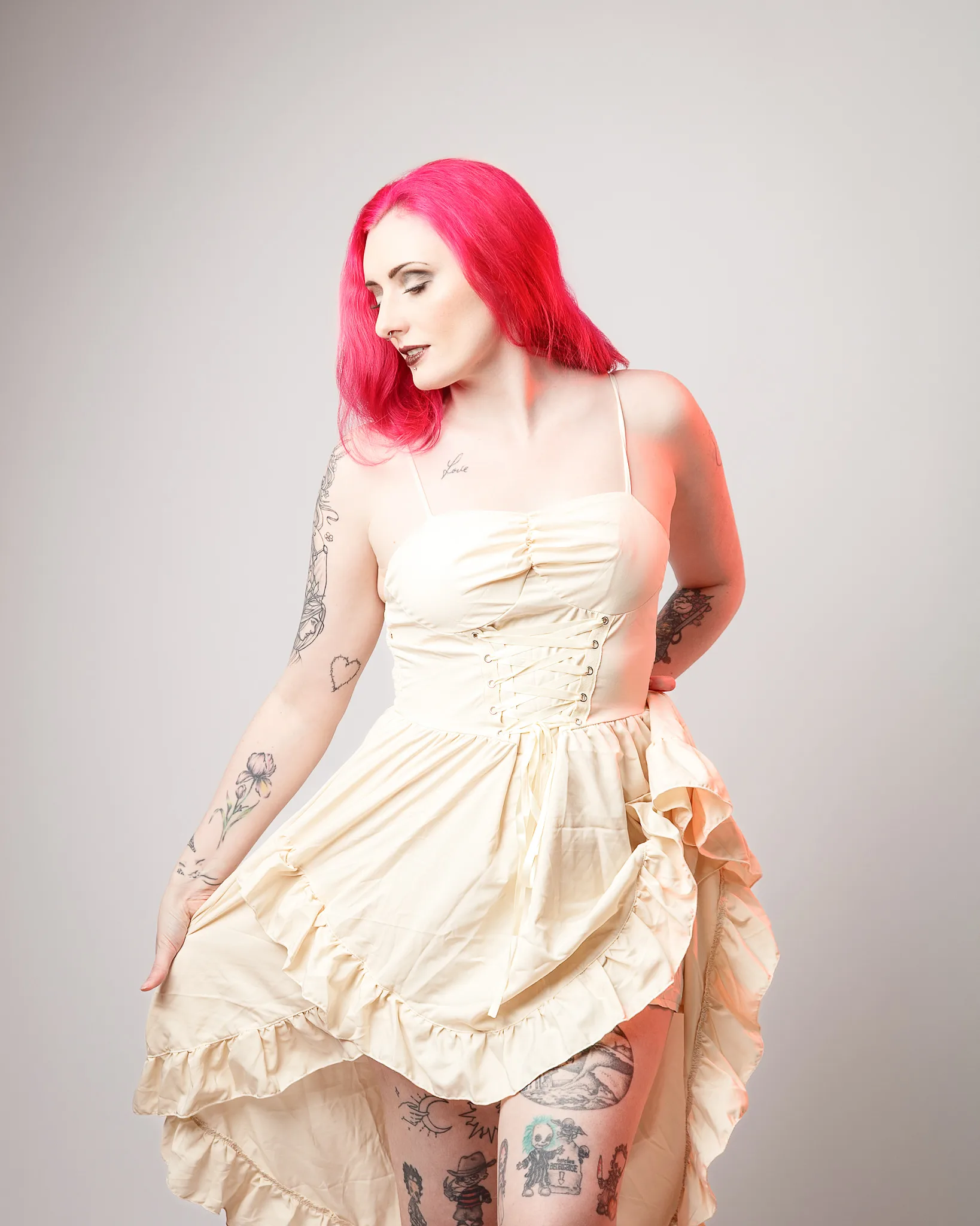 Woman with vibrant pink hair wearing cream corset dress
