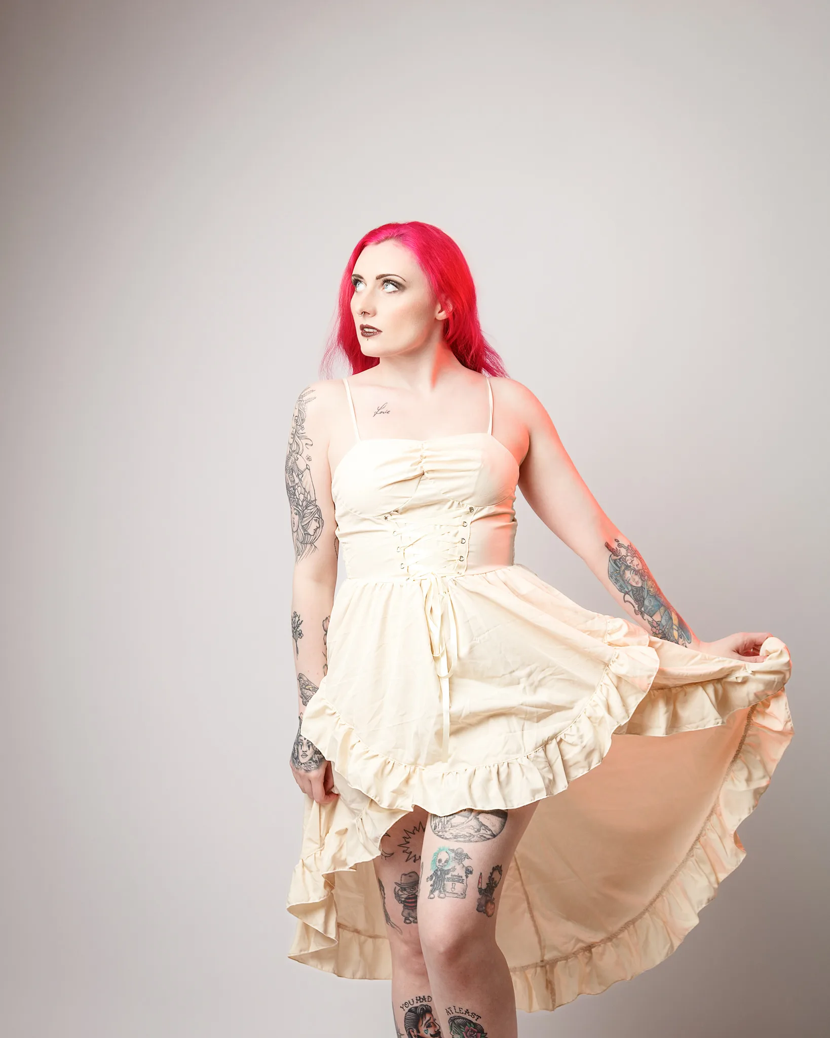 Woman with vibrant pink hair wearing cream corset dress