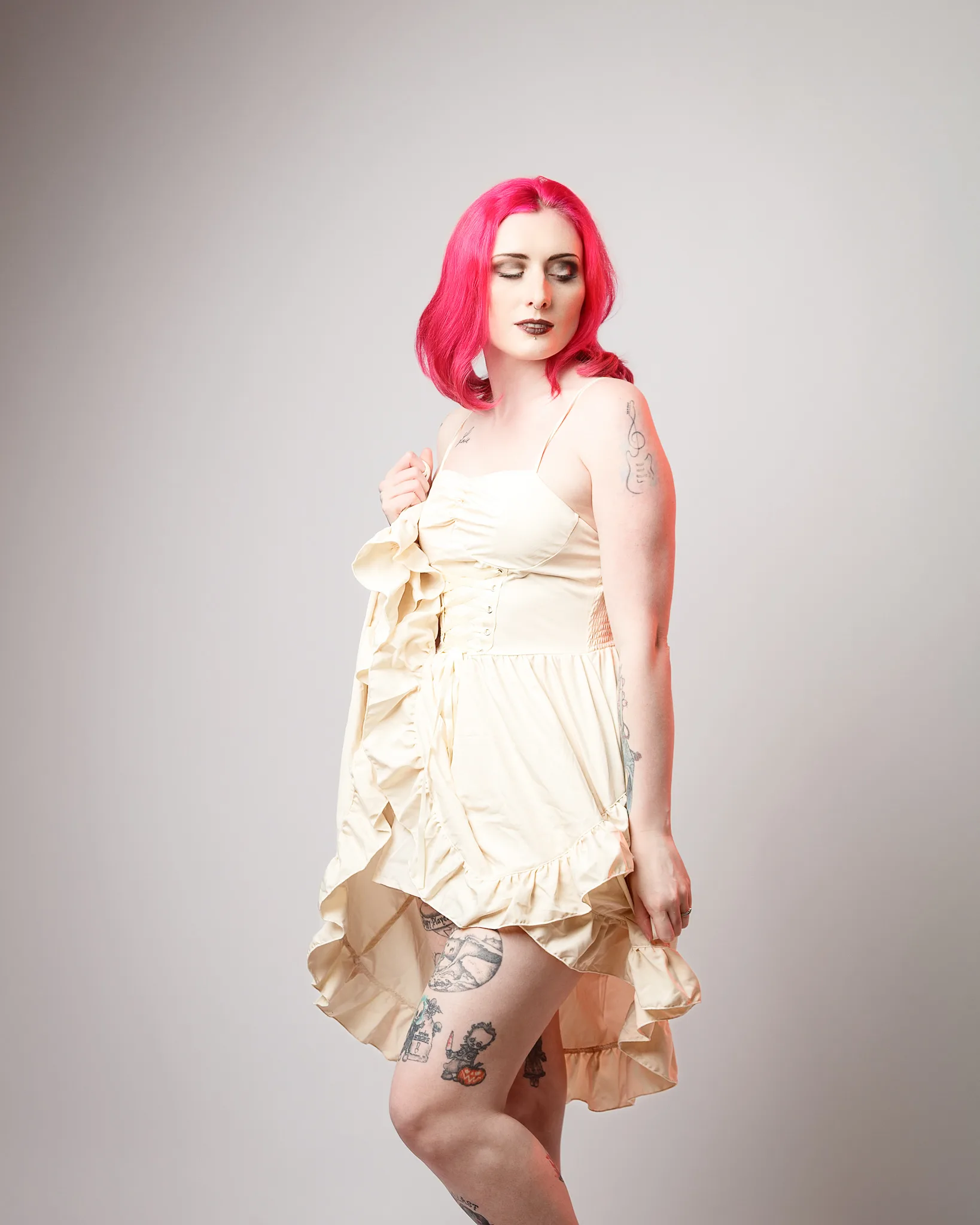 Woman with vibrant pink hair wearing cream dress