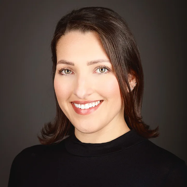 Professional headshot of smiling woman with dark hair